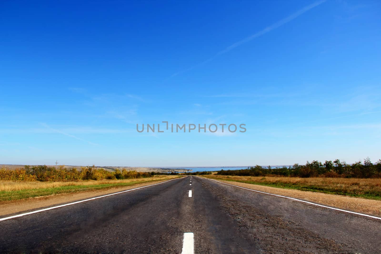 Summer landscape with line of road and blue sky