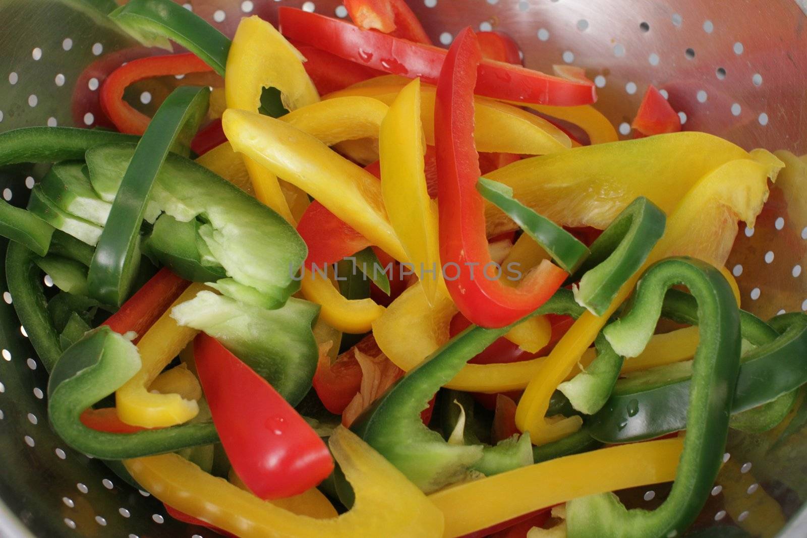 many pepper slices on a wooden background