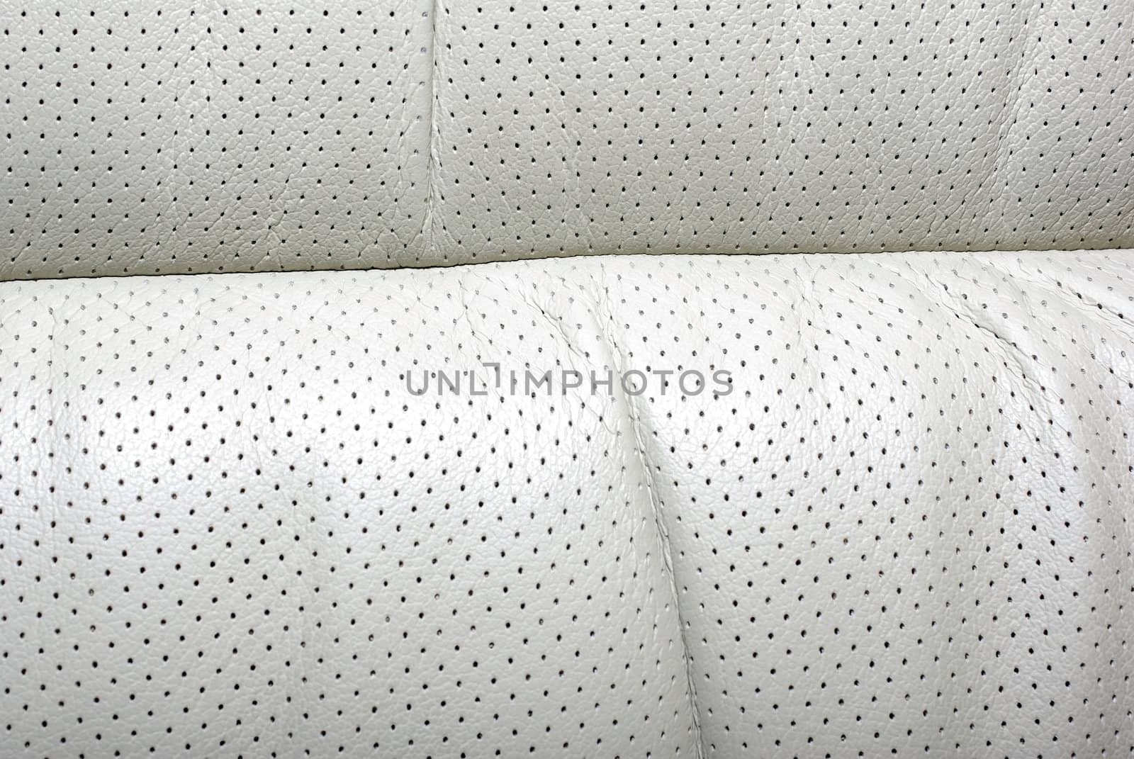 High quality perforated beige car leather textured background.