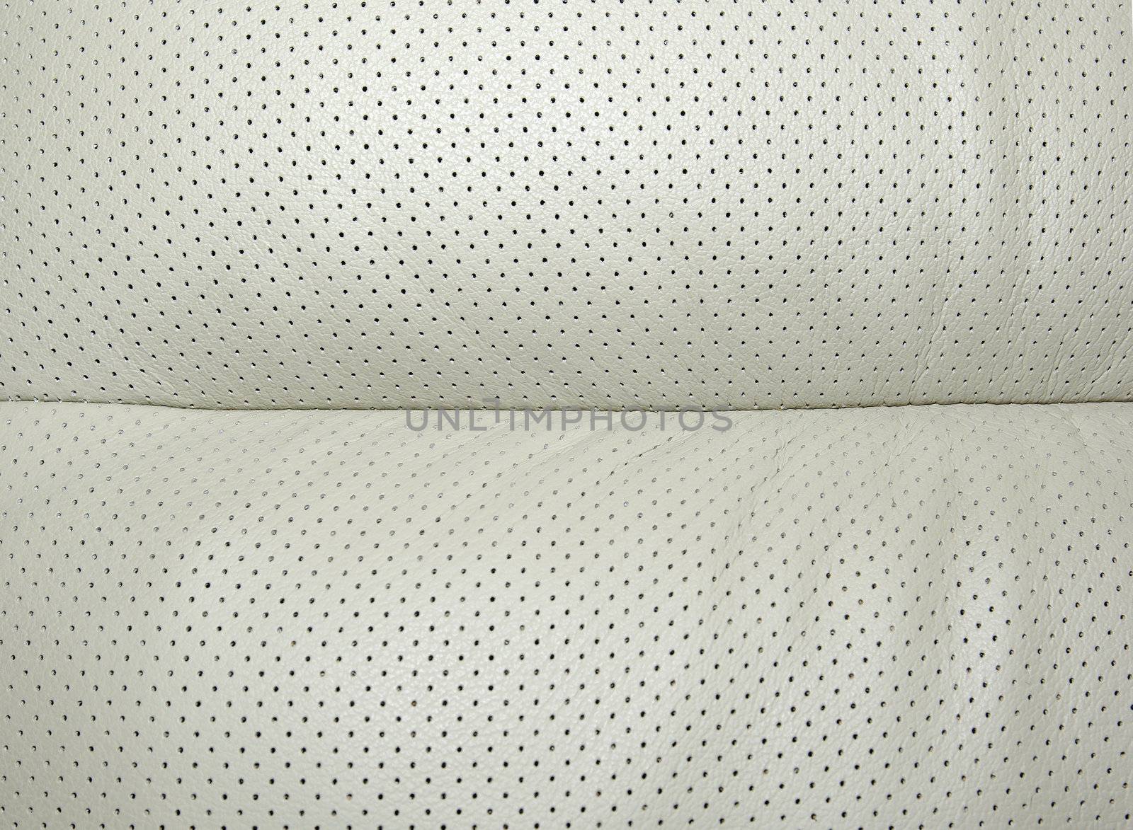 Beige perforated leather - part of modern japanese car interior. Background or backdrop.