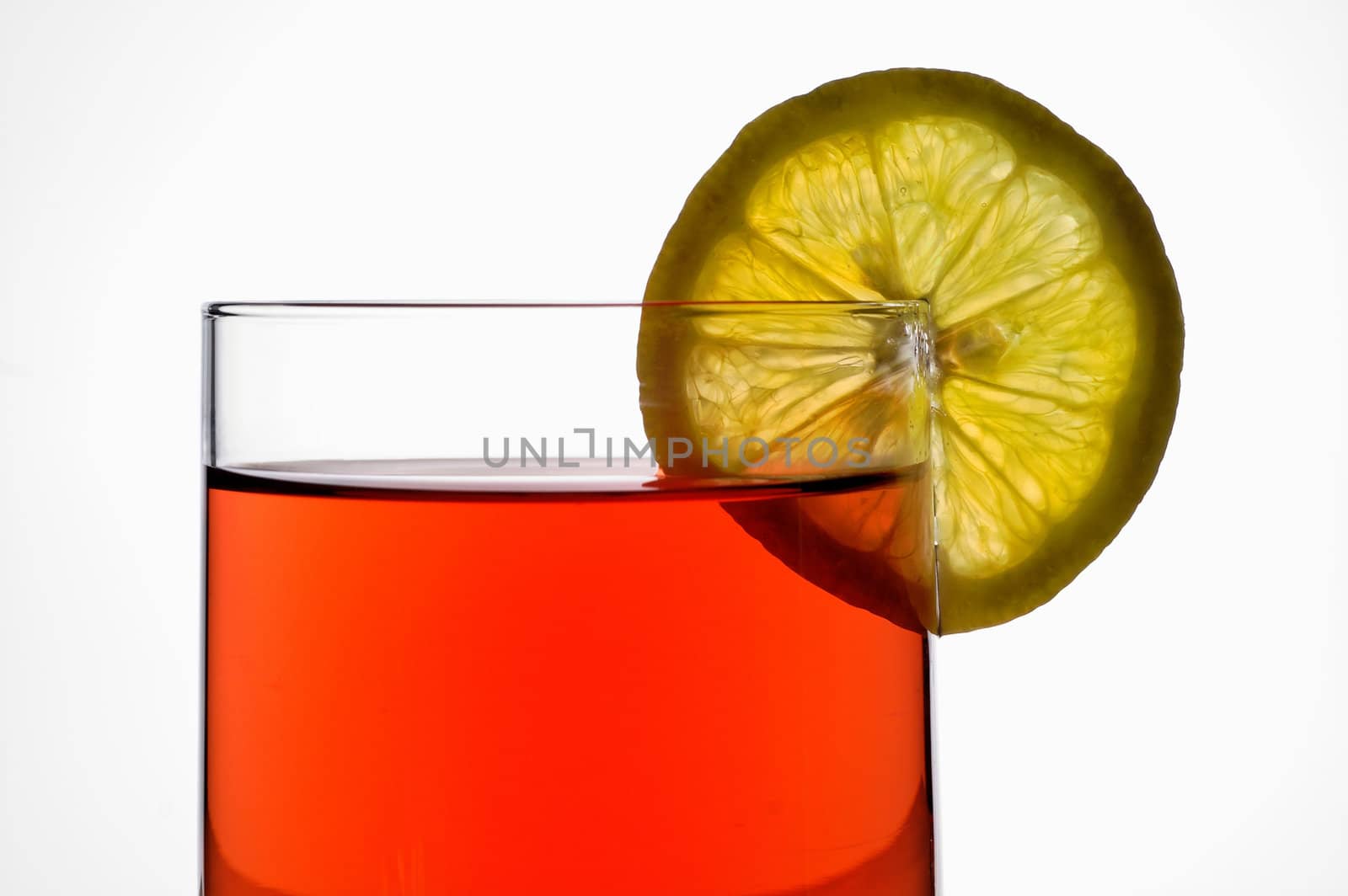 Glass of red liquid (wine,  tea, etc.) with lemon slice closeup with clipping path by Laborer