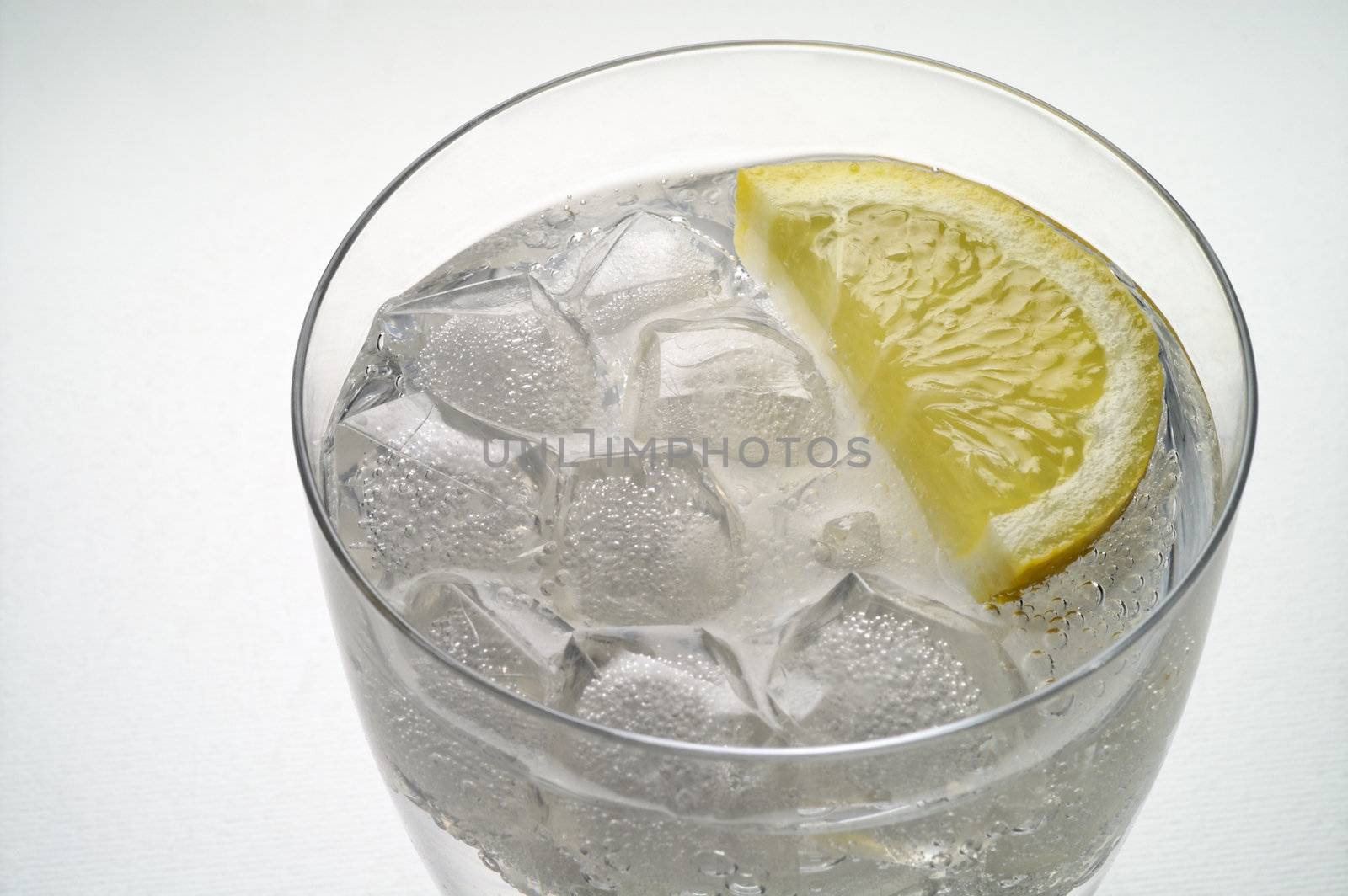 Glass of water (or liquor) with ice and  lemon slice closeup (2)