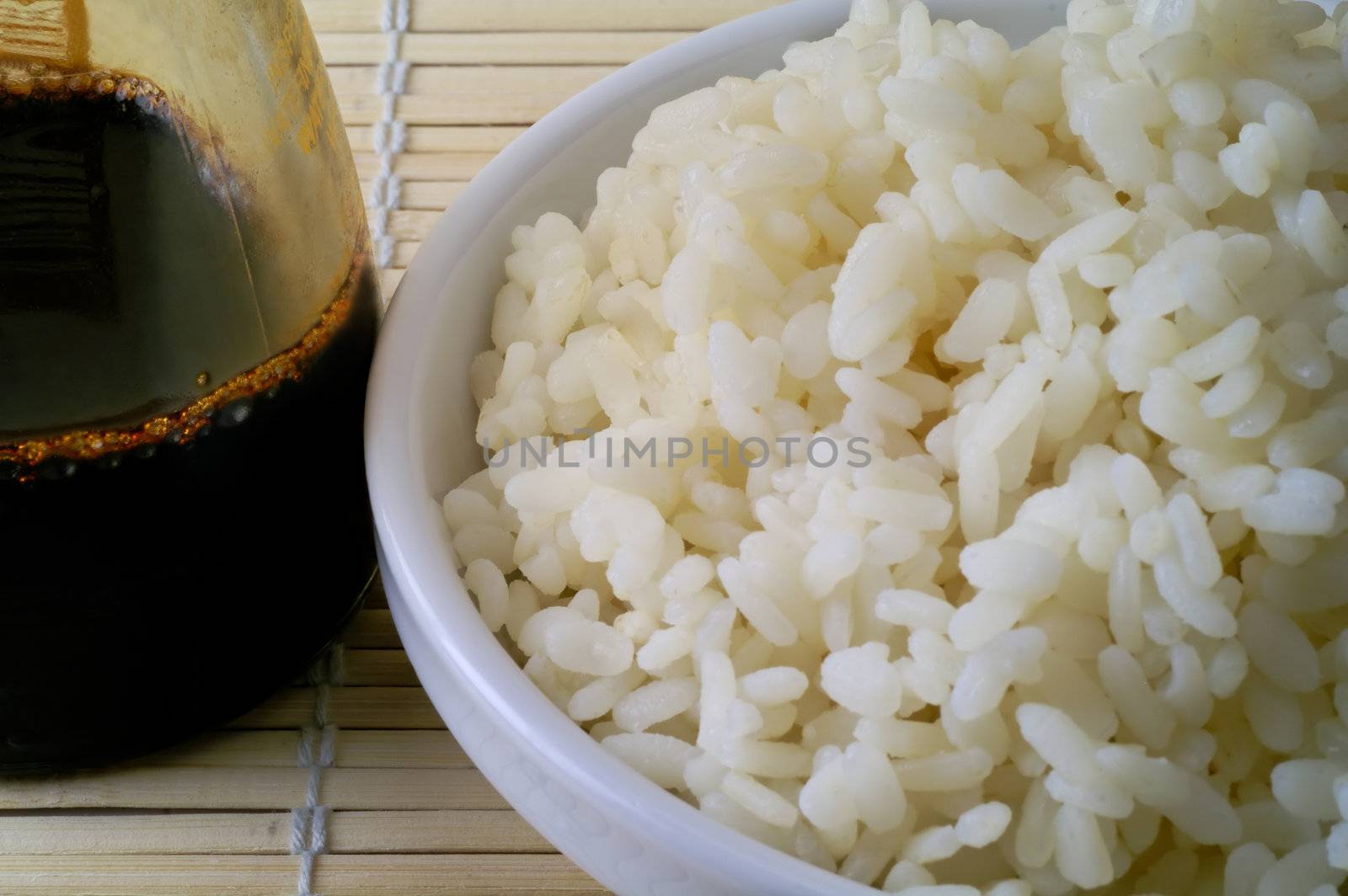 Rice bowl and soya sauce on bamboo mat (2) by Laborer