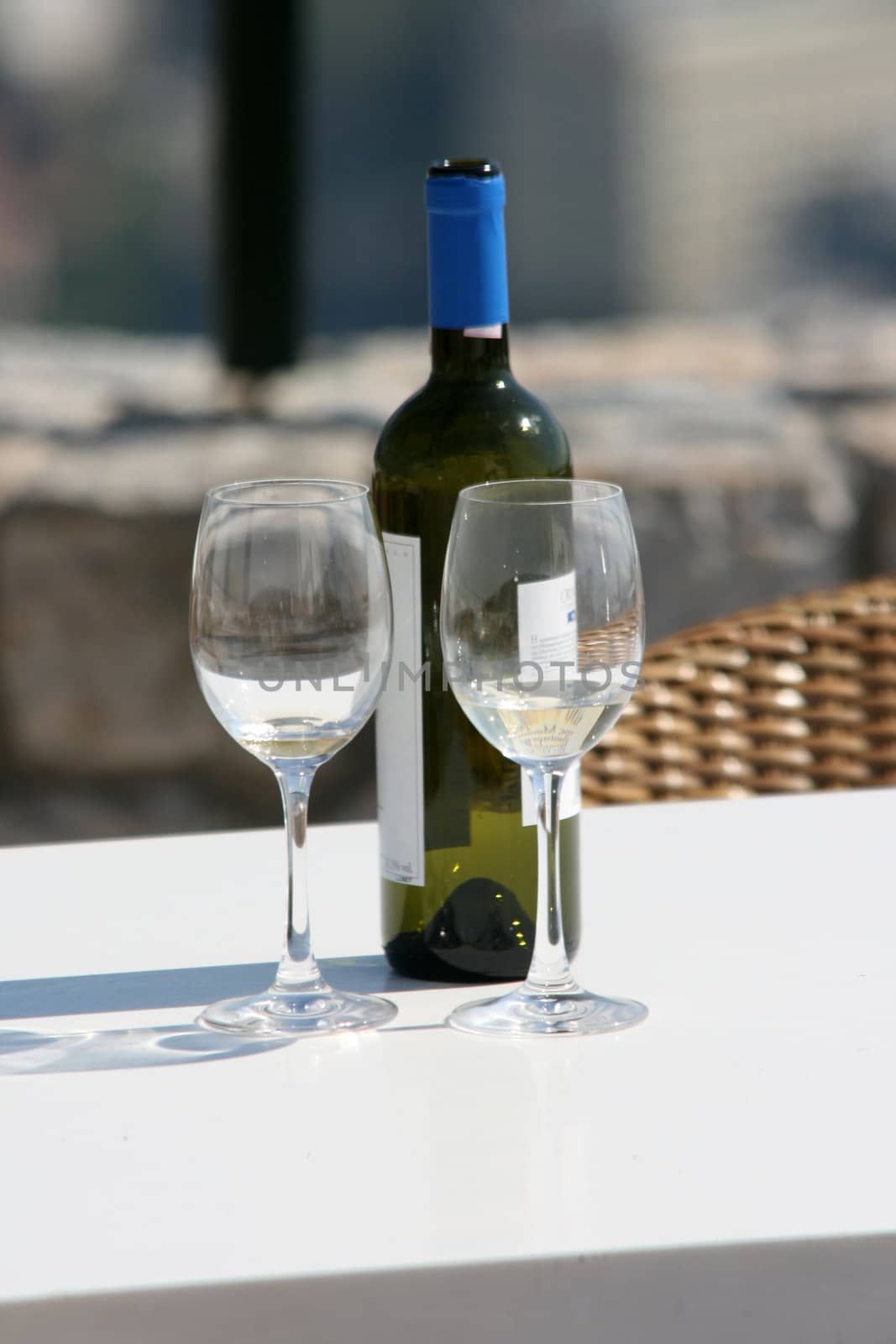 two wine glasses and a bottle in a siny day