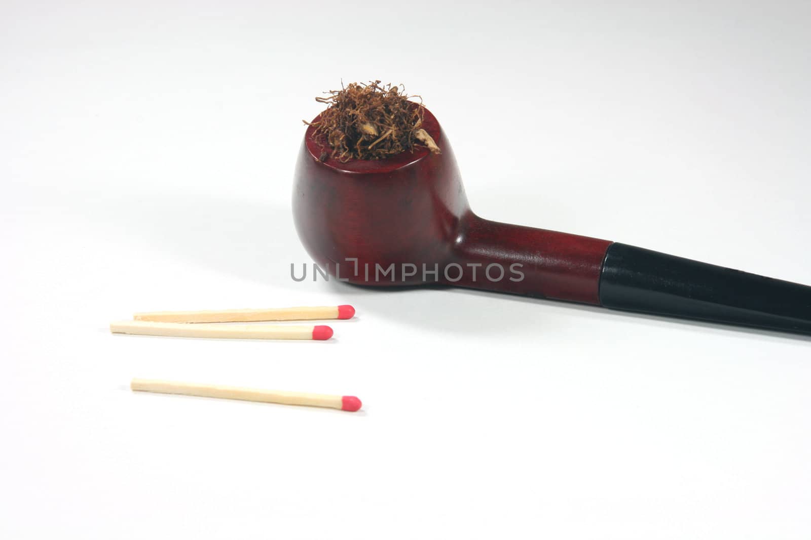 old wooden tobacco pipe with matches in white background