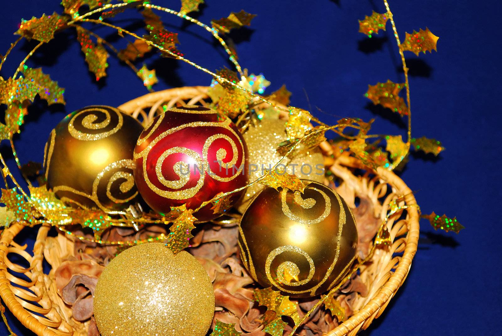 Color christmas ornaments in the bascket are on the blue background. 