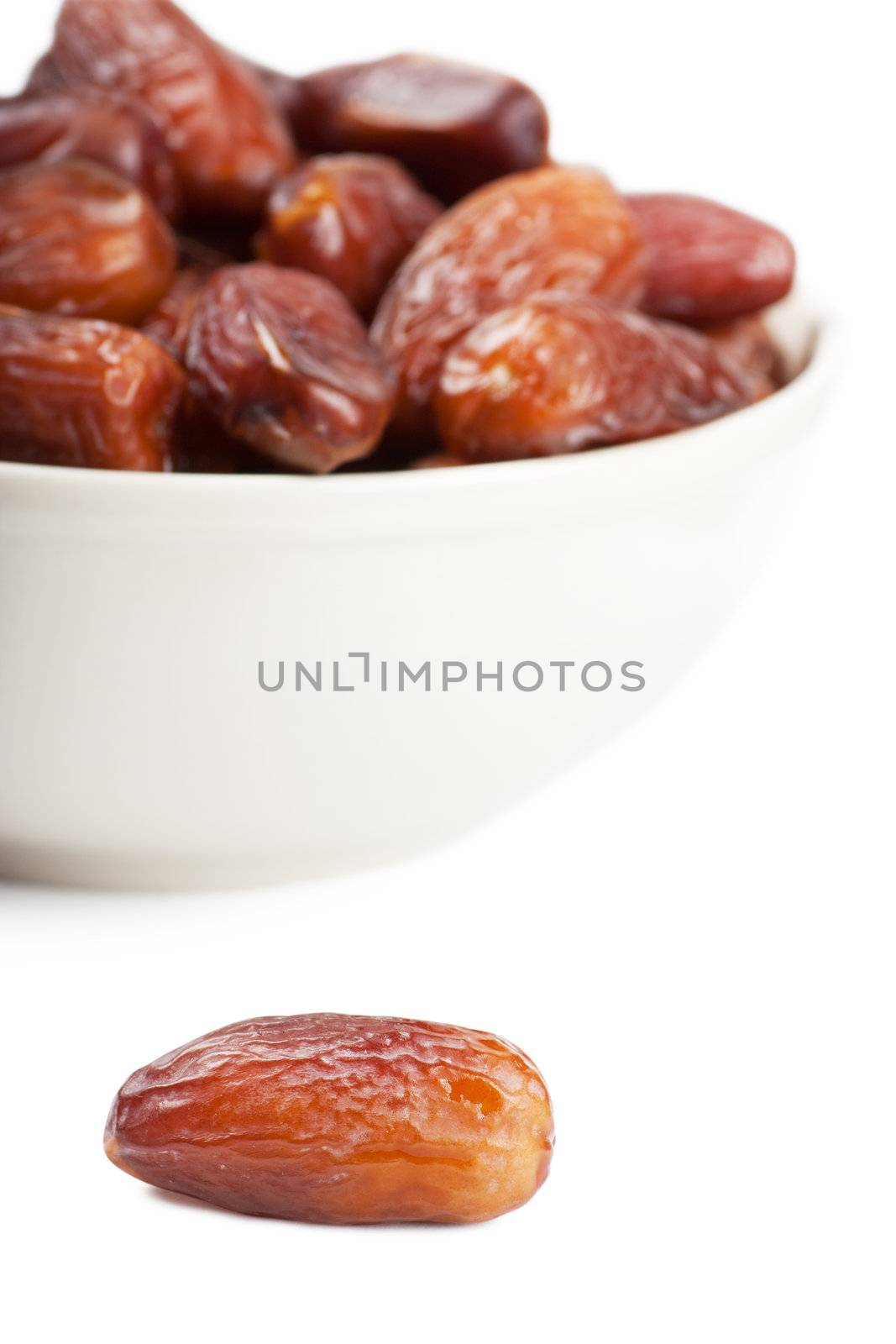 Sweet dates in a white bowl isolated over white background