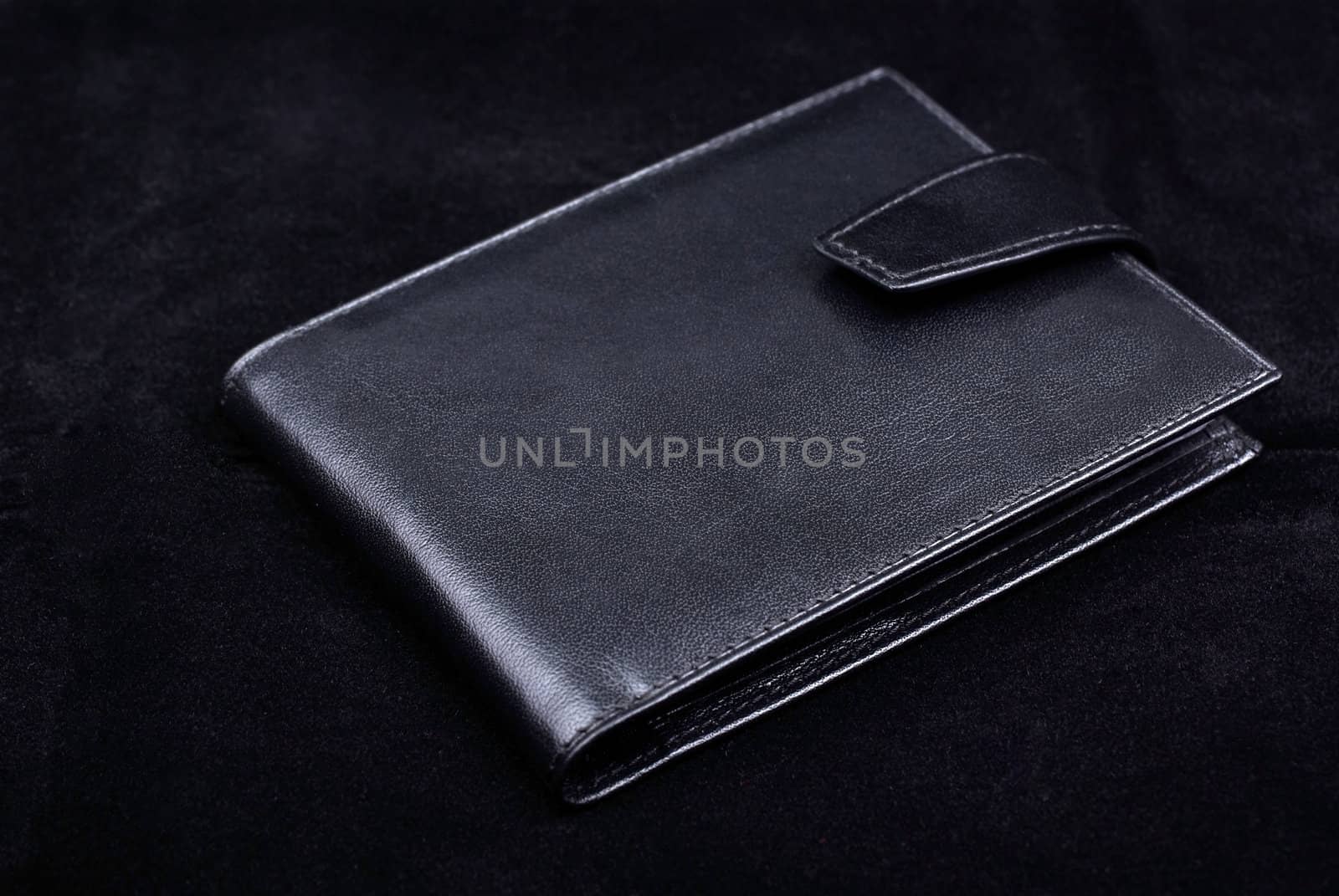 New wallet made of high quality leather isolated on black velvet background. Studio shot.