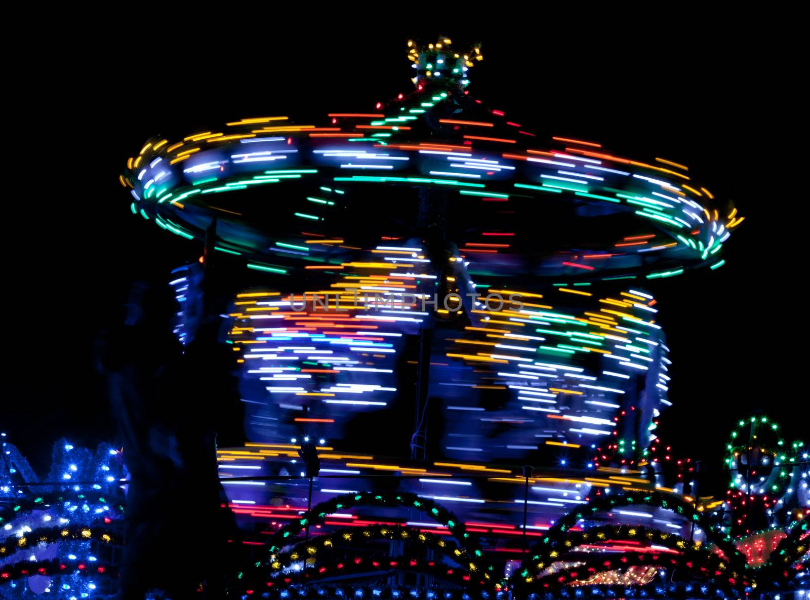 Merry-go-round twisting fast in the night with thousands lights