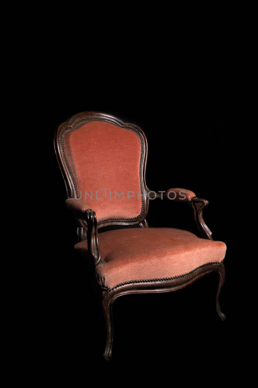 antique red armchair on a black background