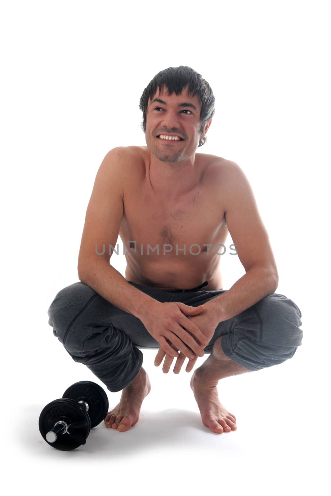young man and dumbbells sitting in front of white background