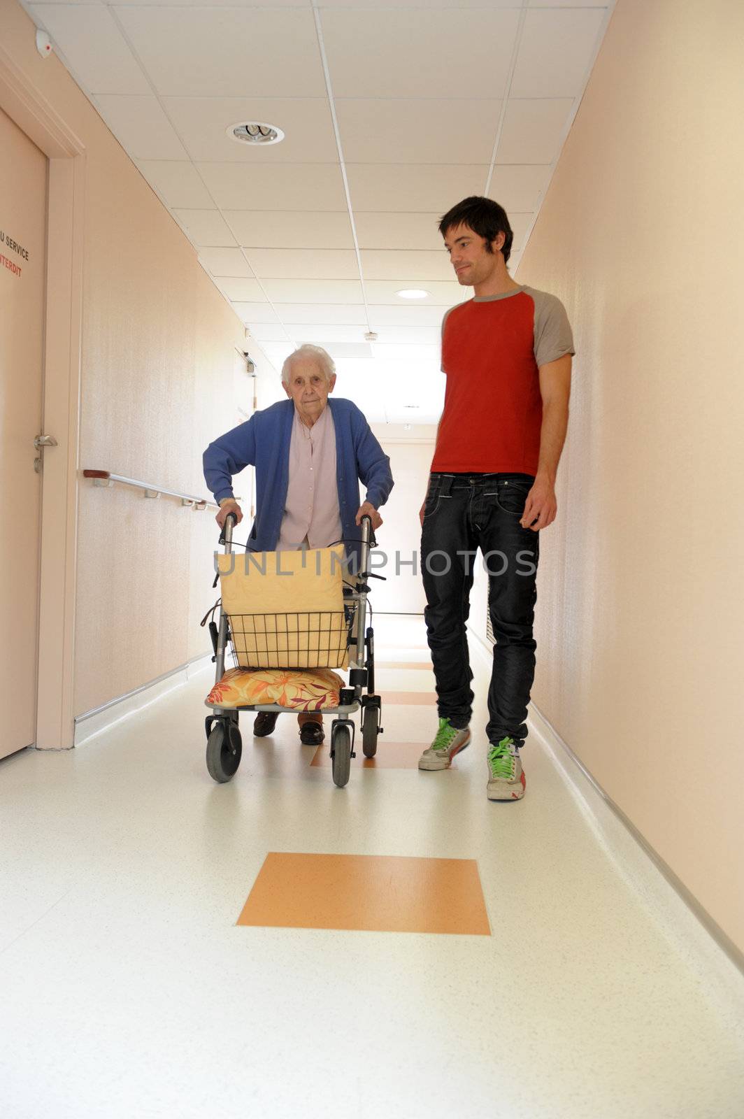 senior woman pushing a walking frame in a  retirement facility