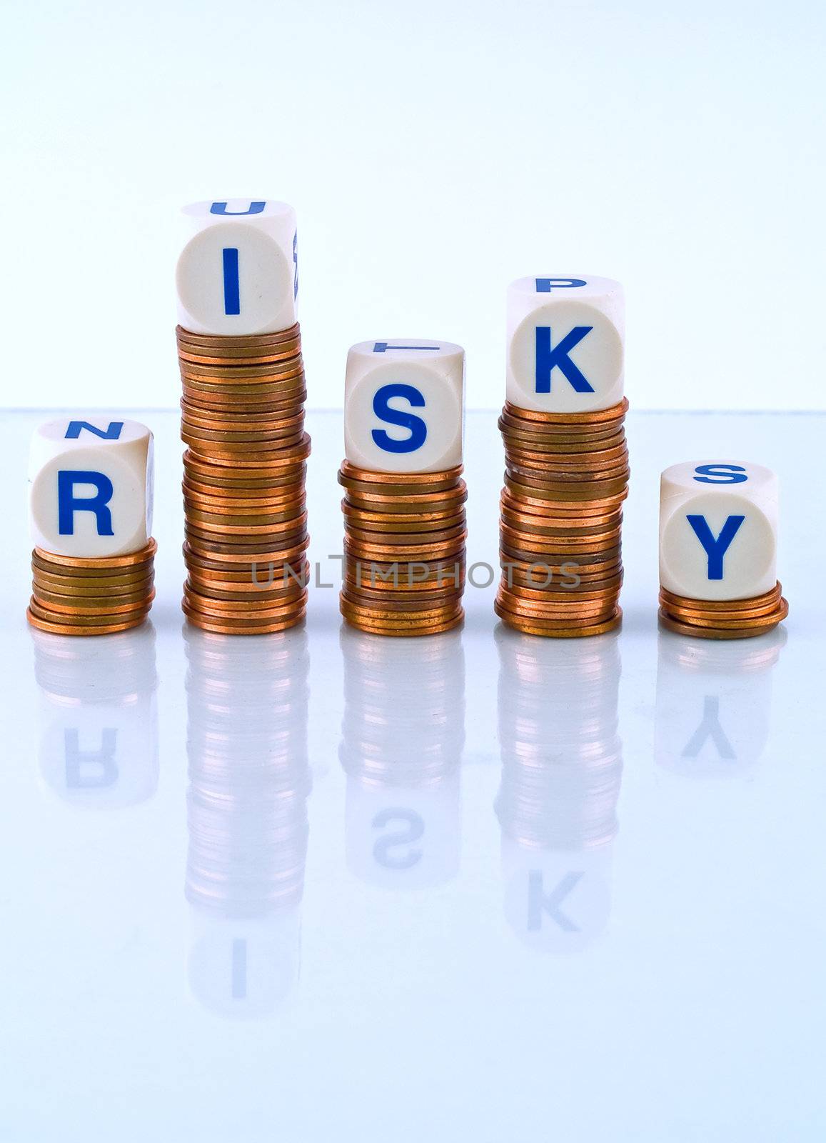 Letter Dice Spelling Risky atop Penny Stacks