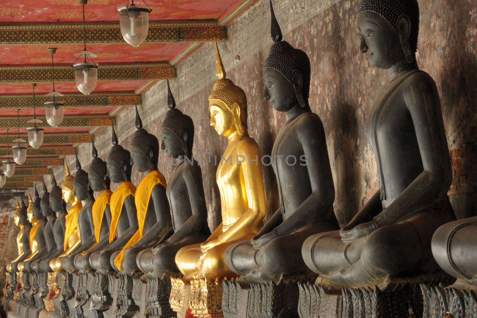 Row of the sacred Buddha image in temple, Thai. by ngungfoto