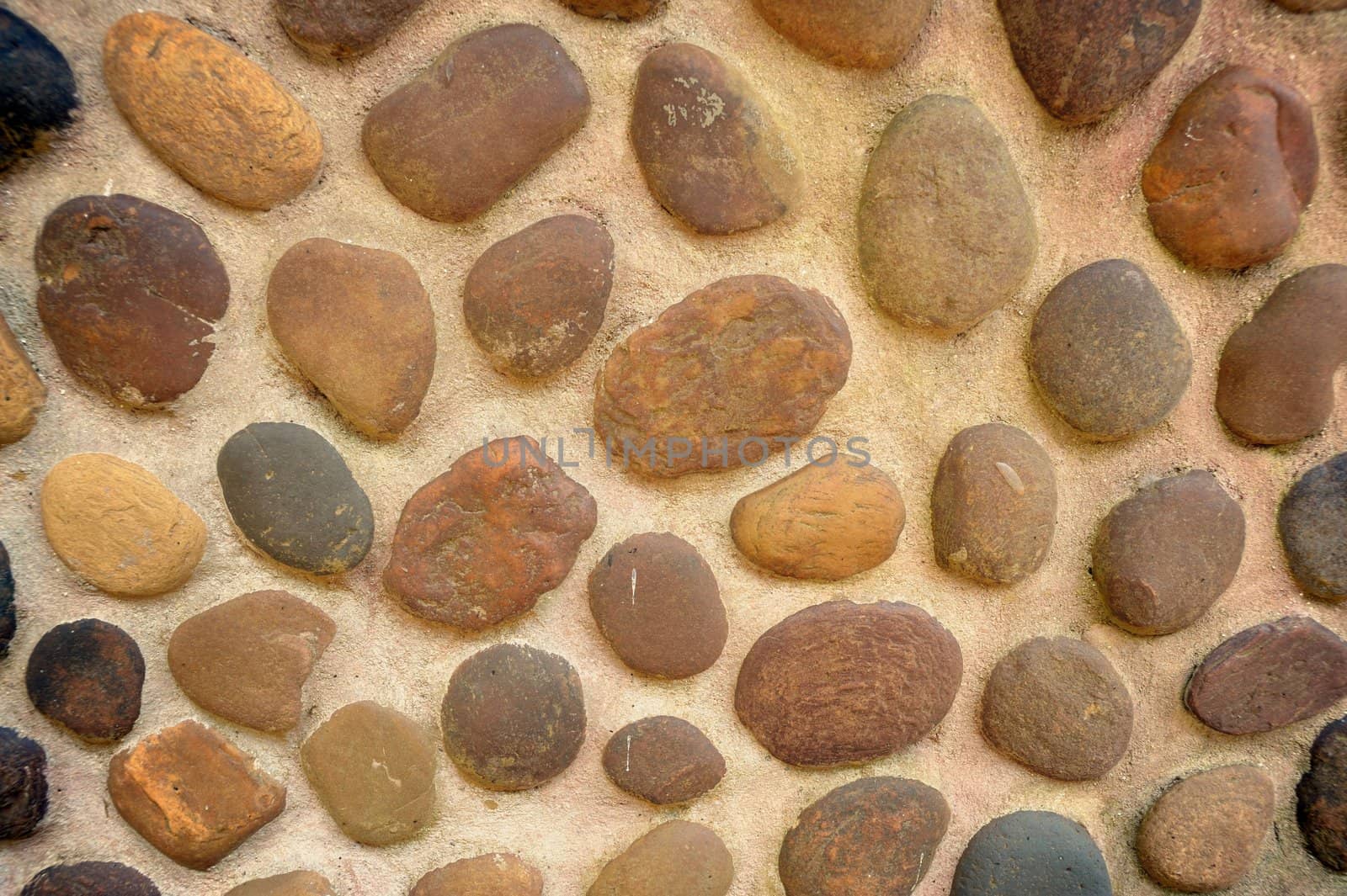 Abstract pebbles round textured wall. by ngungfoto