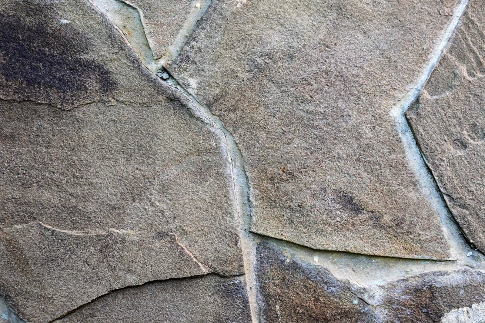 Textured wall made of broken brown decorative stone.