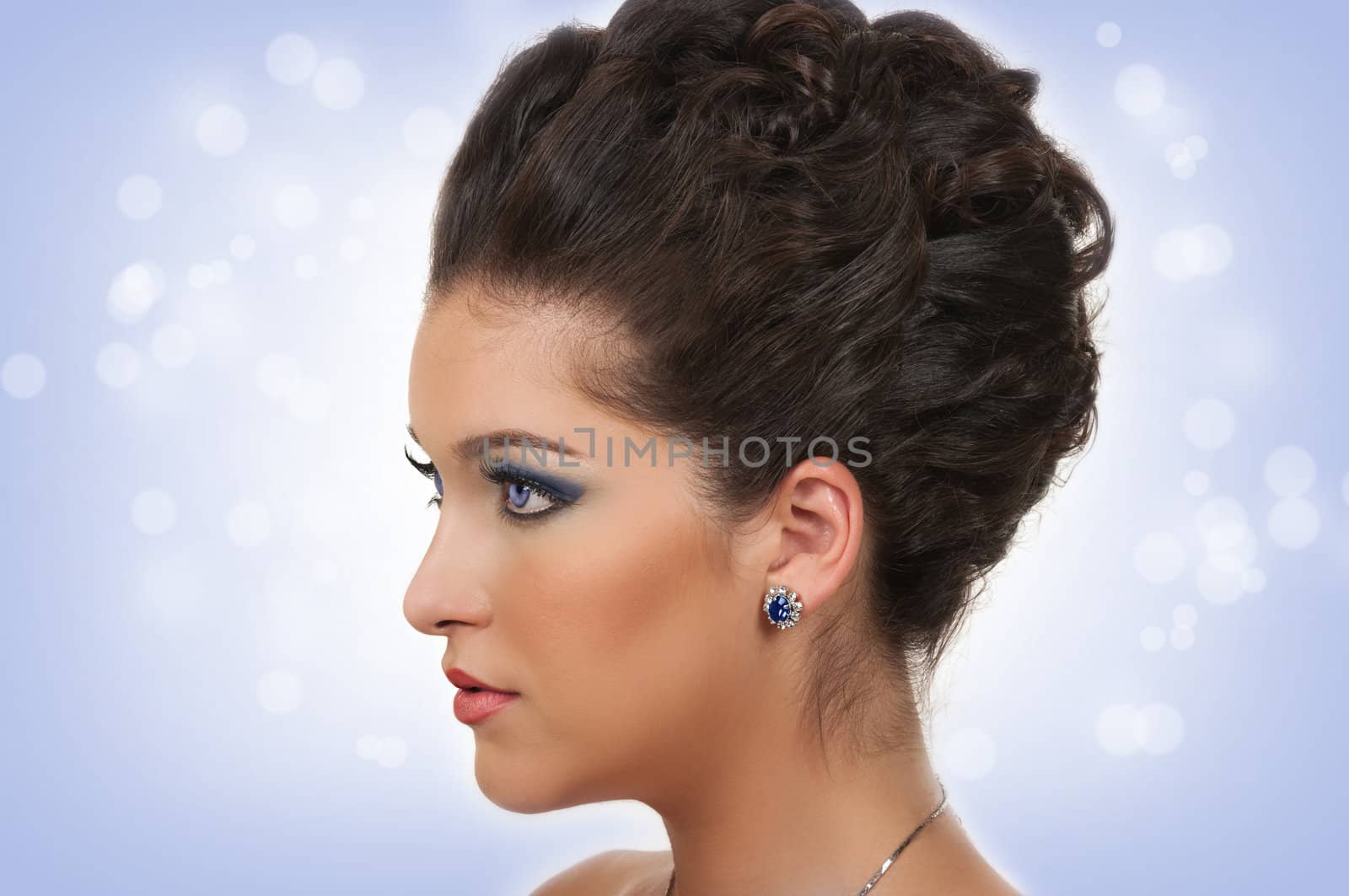 Young woman with beautiful hairstyle, make up and sapphire jewelry