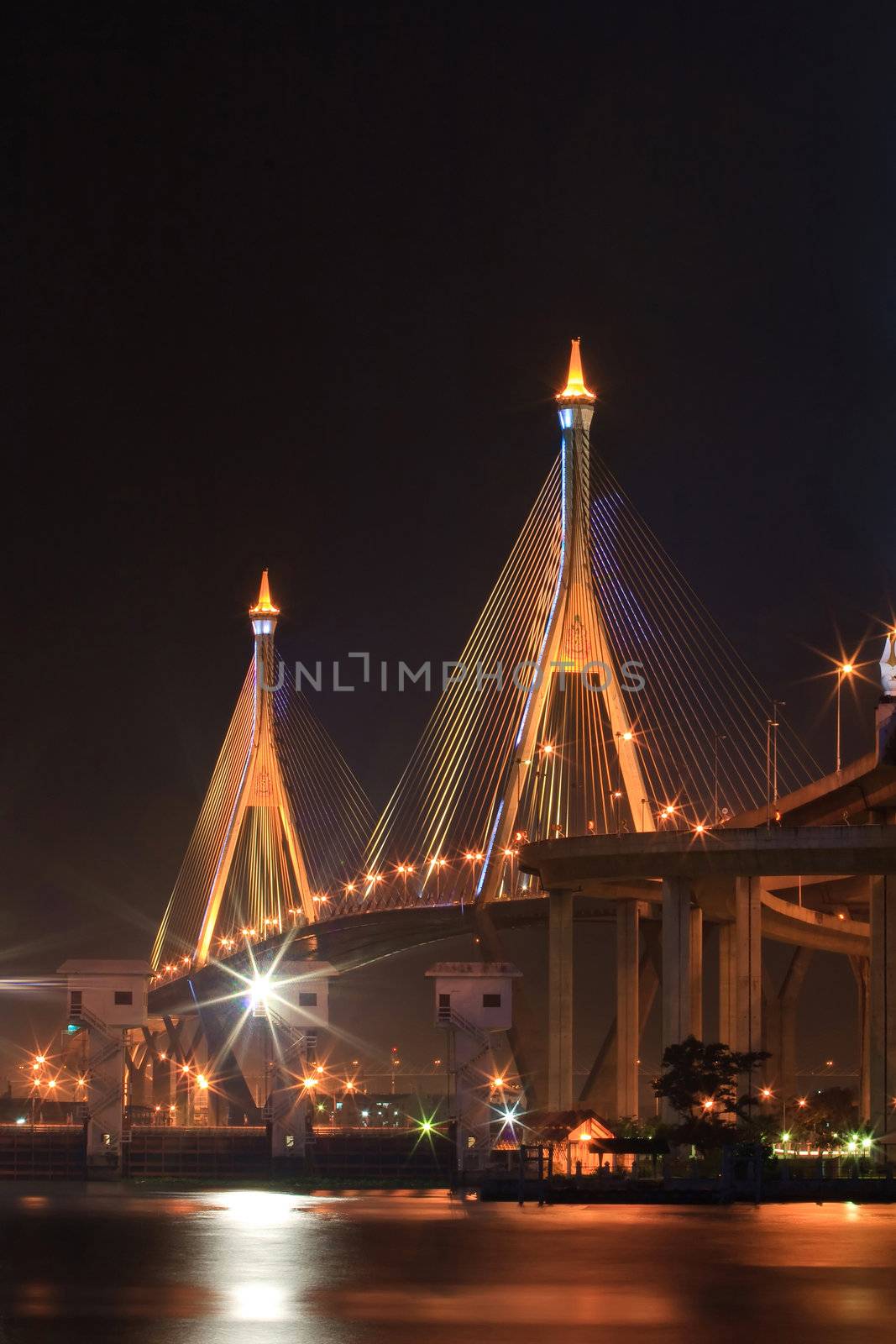 The Industrial Ring Bridge shines at dusk with Vertical perspective in Thailand.. The Bridge cross over ChaoPhraya River and Bangkok Harbor