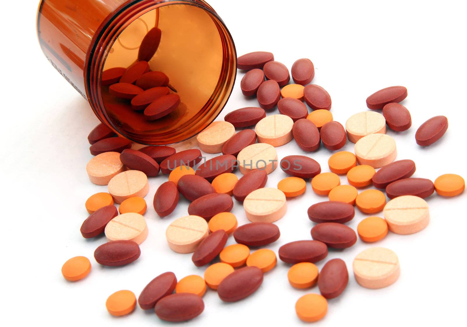 Persepctive of Open pill bottle with medicine spilling out isolated on white background