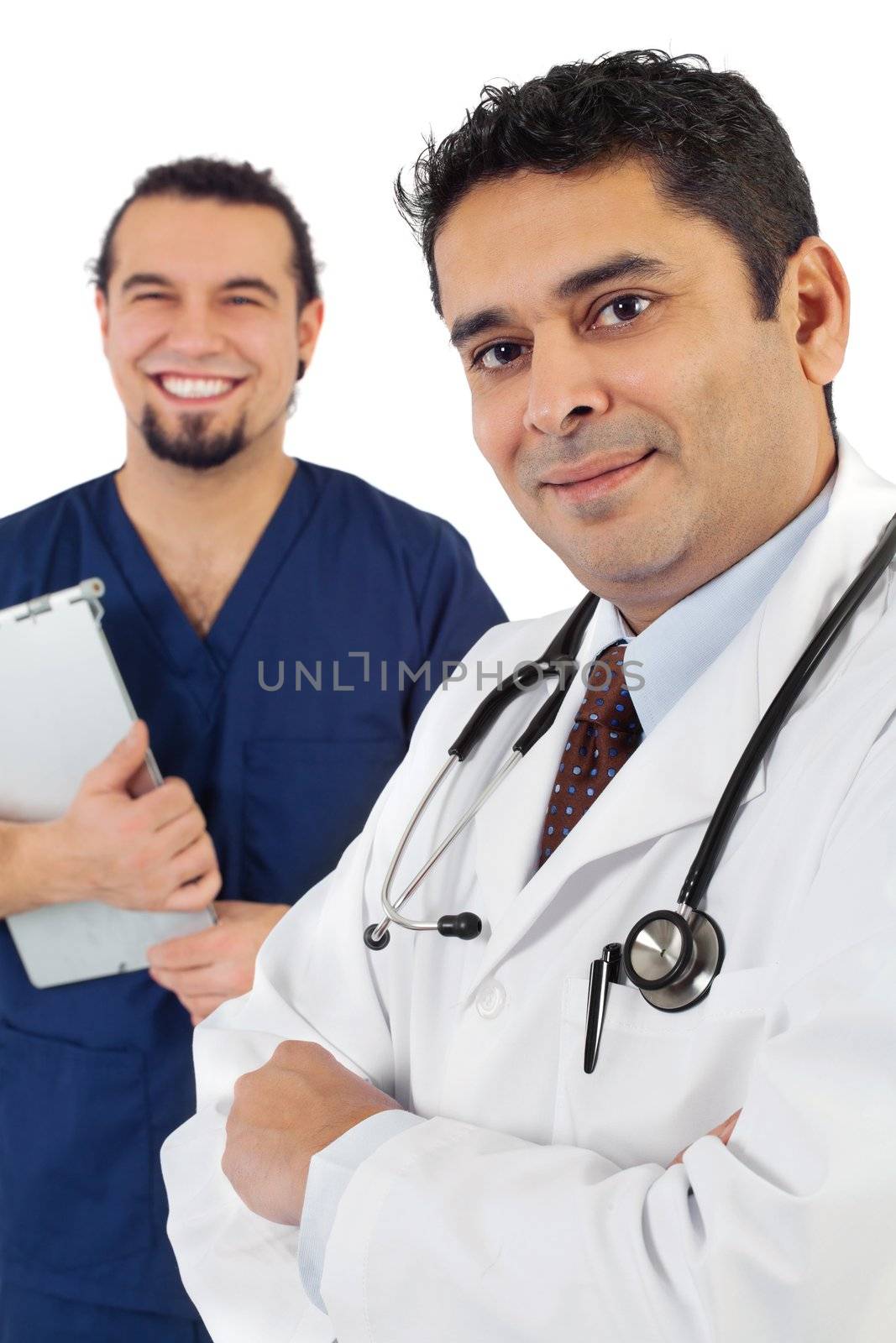Photo of two doctors standing together smiling. Focus is on doctor on right.