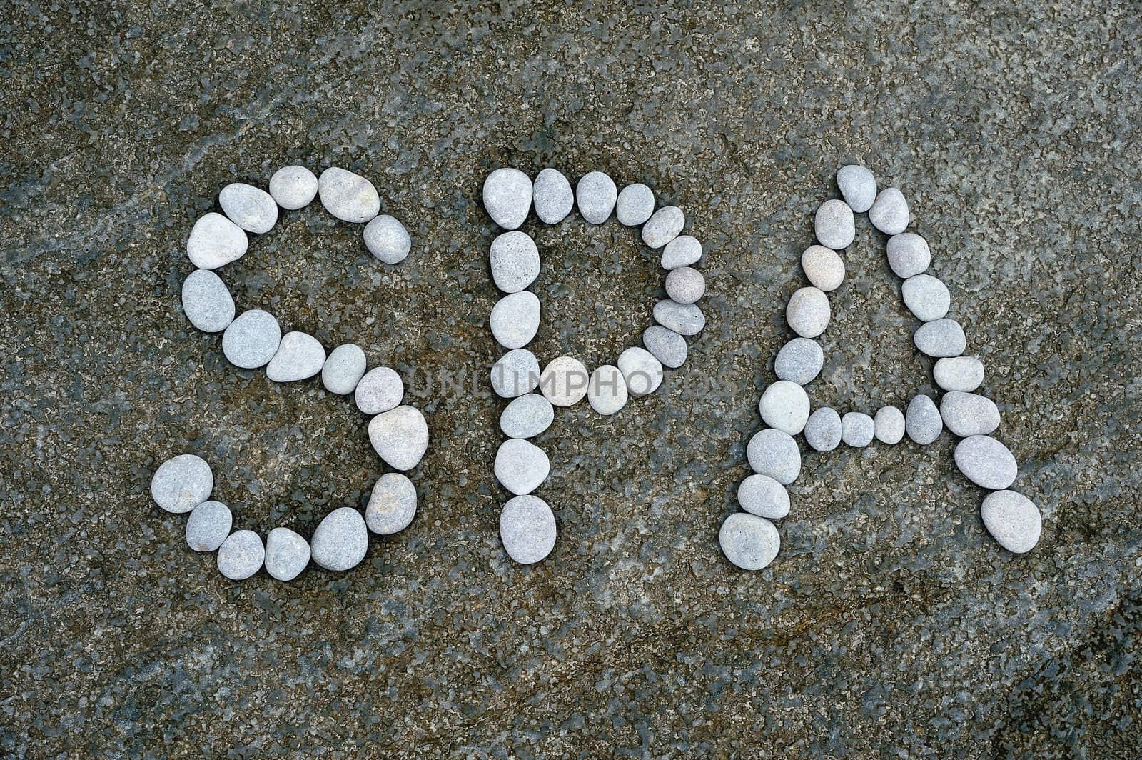 The word Spa made from a pebbles on the surface of boulder