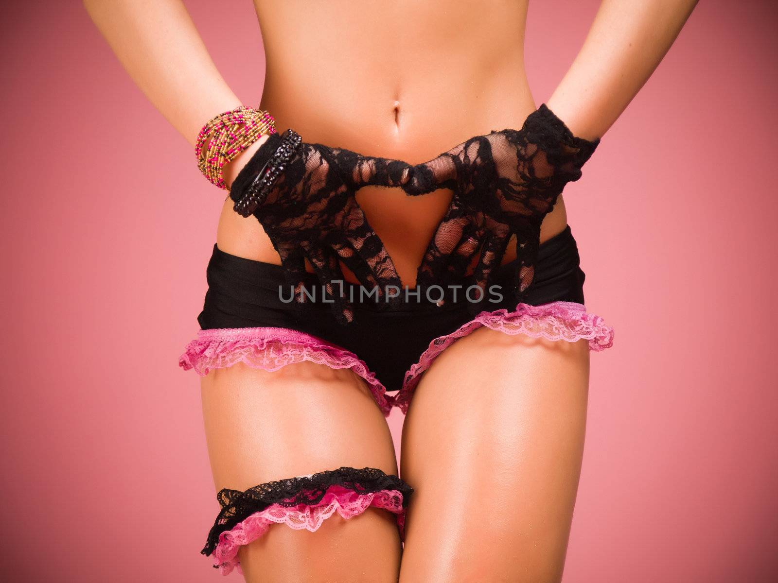 Torso and hips of a female dancer wearing black and pink lace lingerie