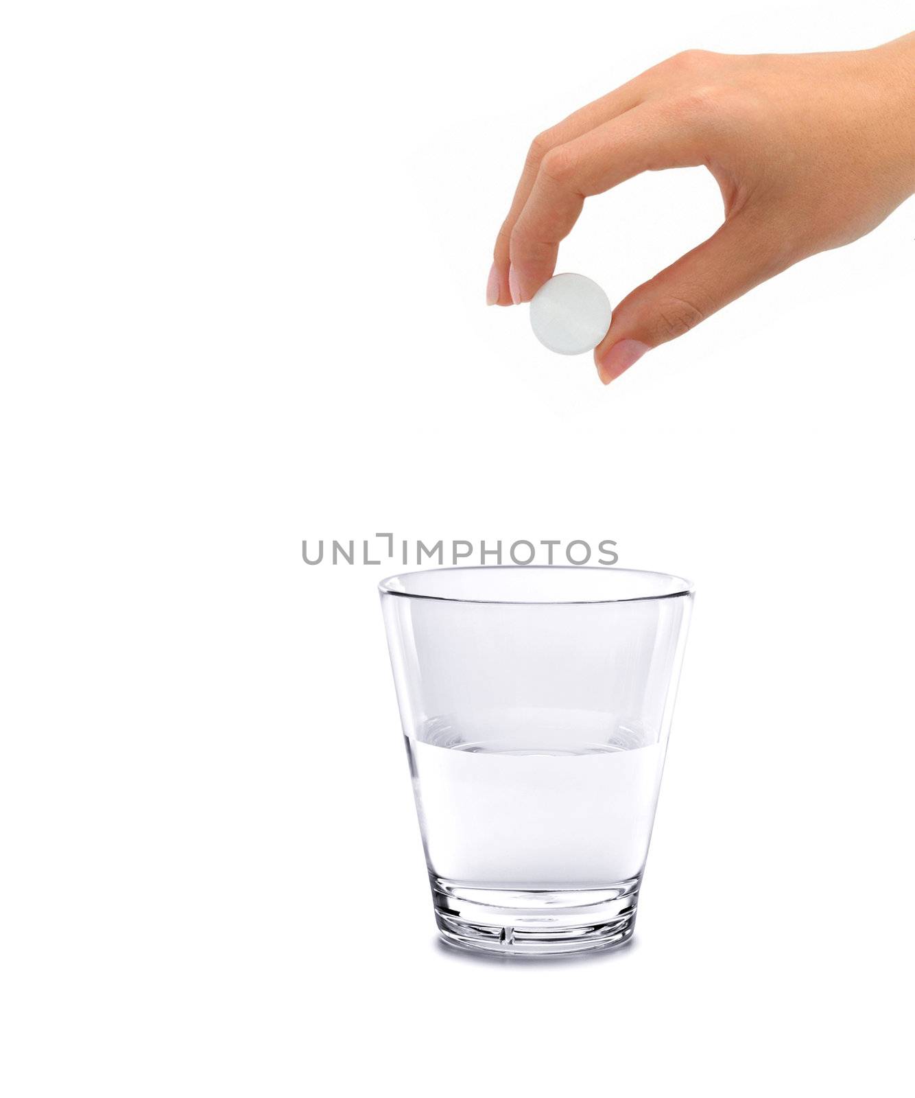 Tablet of sedative in a hand above a glass with water