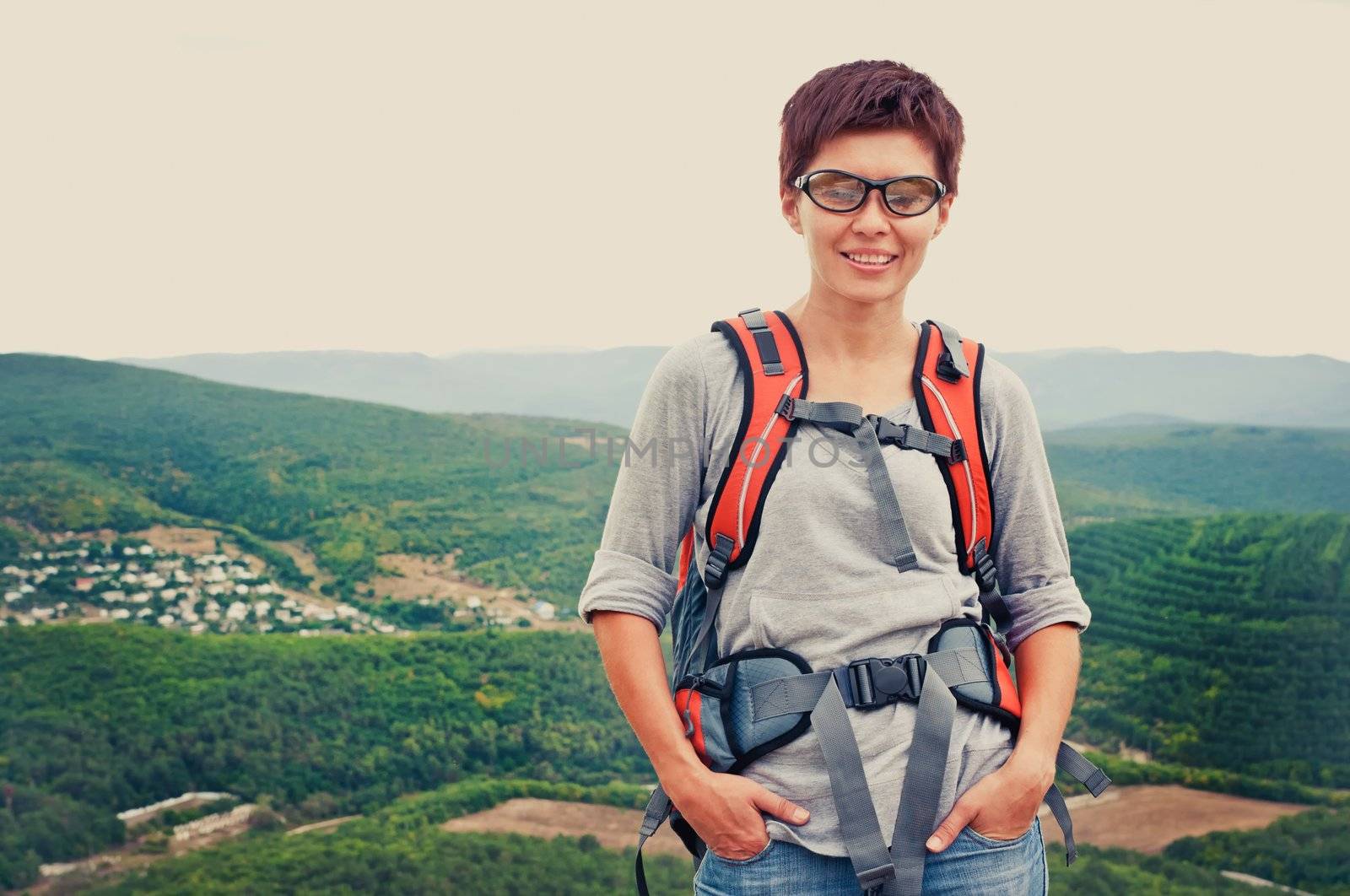 Portrait of smiling girl in glasses on a mountain hill