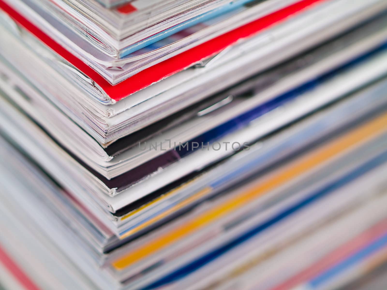 A stack of magazines filling the frame from top to bottom focus on corner edge