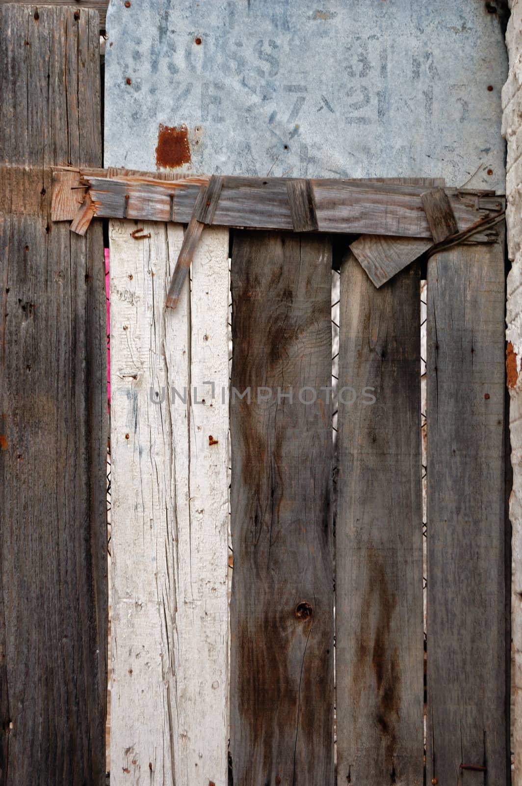 Old wooden barn door made from planks and scrap metal. Background texture.