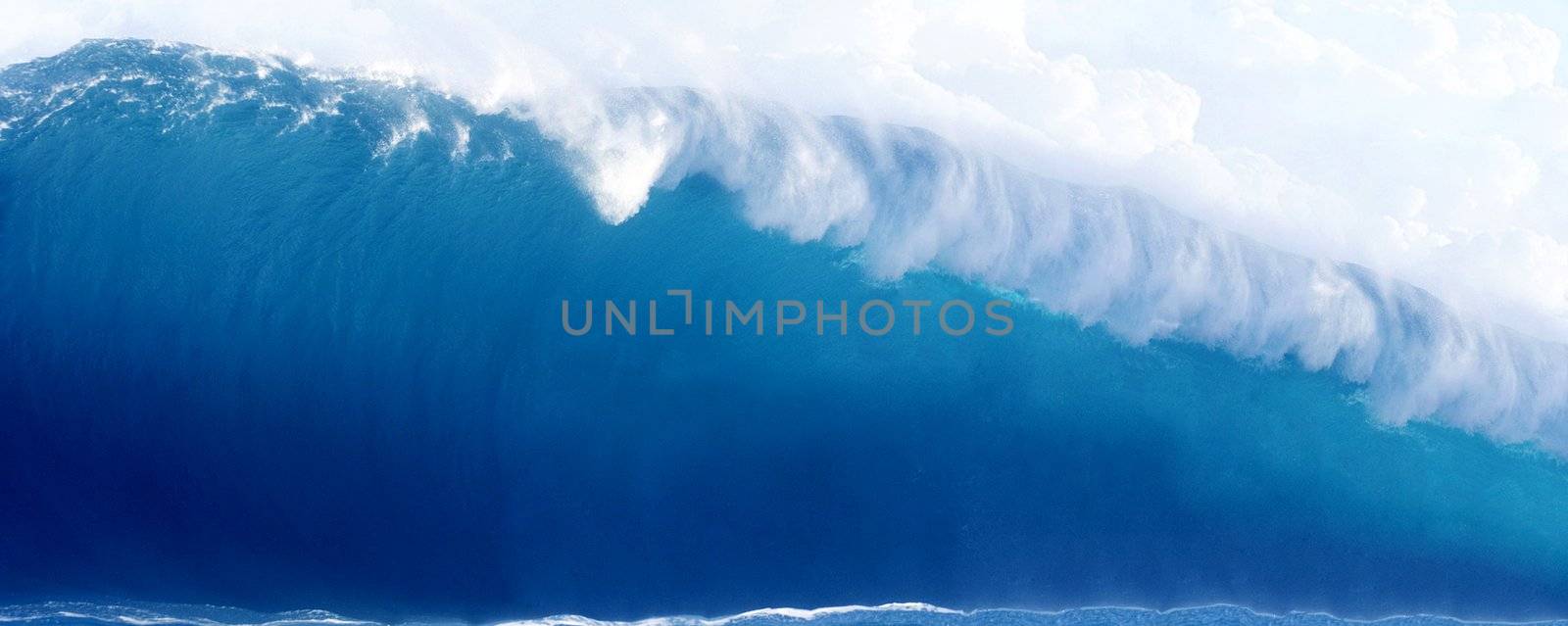 Large Blue Surfing Wave Breaks in the Ocean