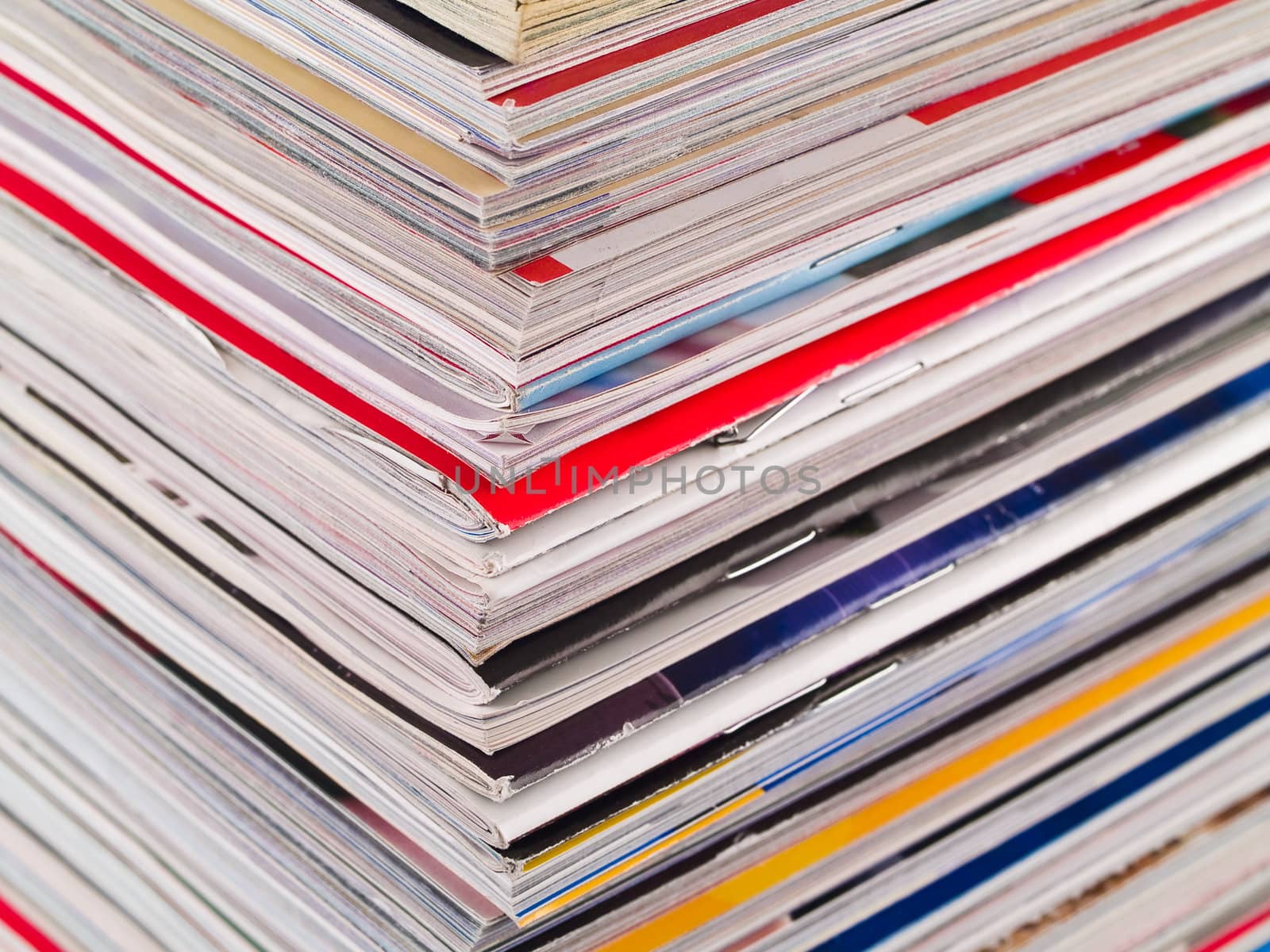 A stack of magazines filling the frame from top to bottom focus on corner edge