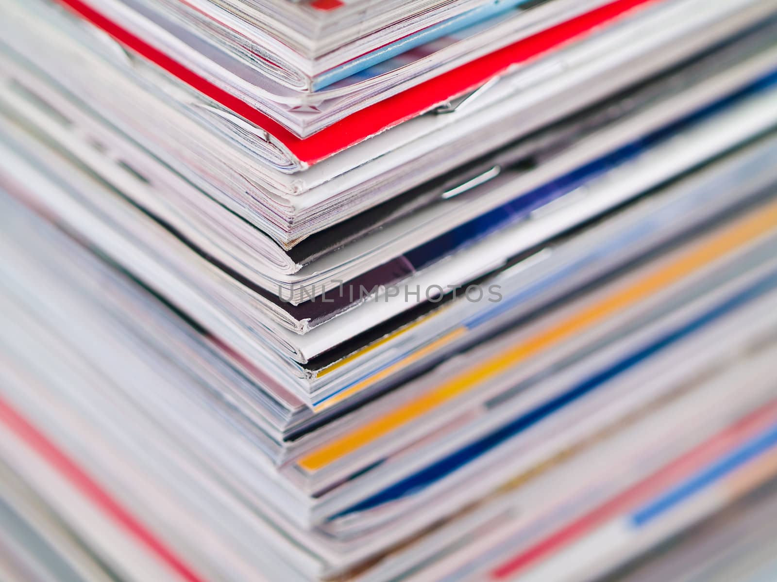 A stack of magazines filling the frame from top to bottom focus on corner edge