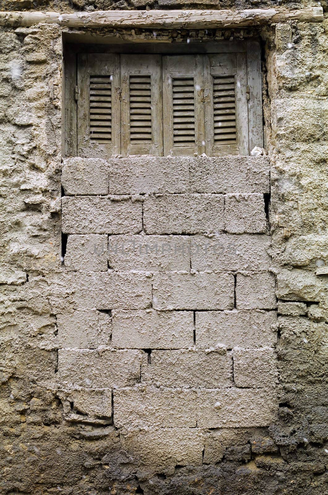 Bricked up window and textured wall of a derelict house.