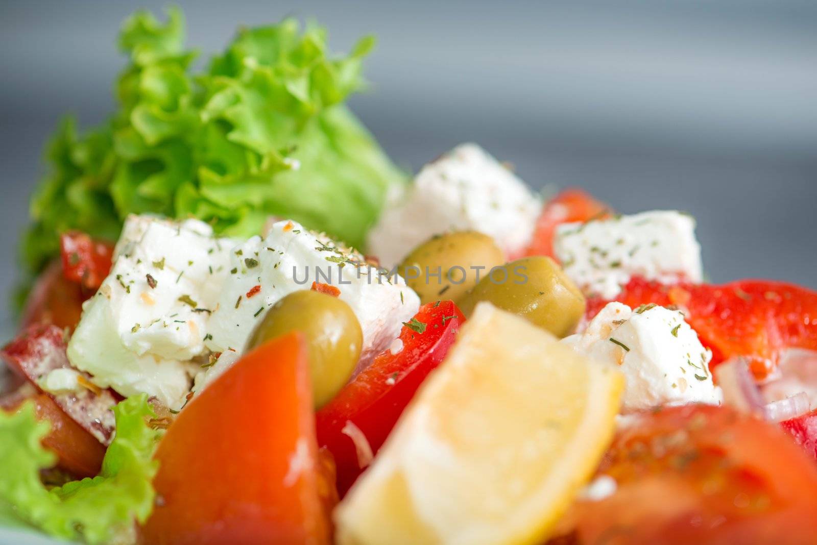 Tasty Greek salad on a plate with lemon