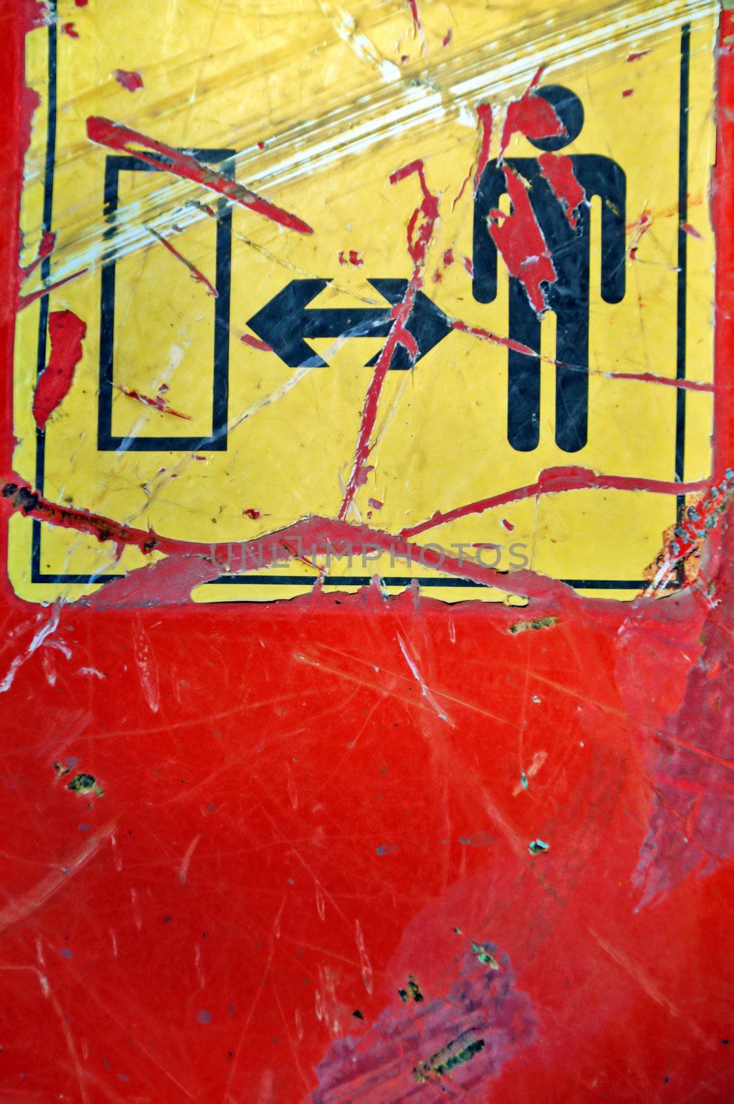Weathered industrial safety sign on rusty construction machinery metal surface.