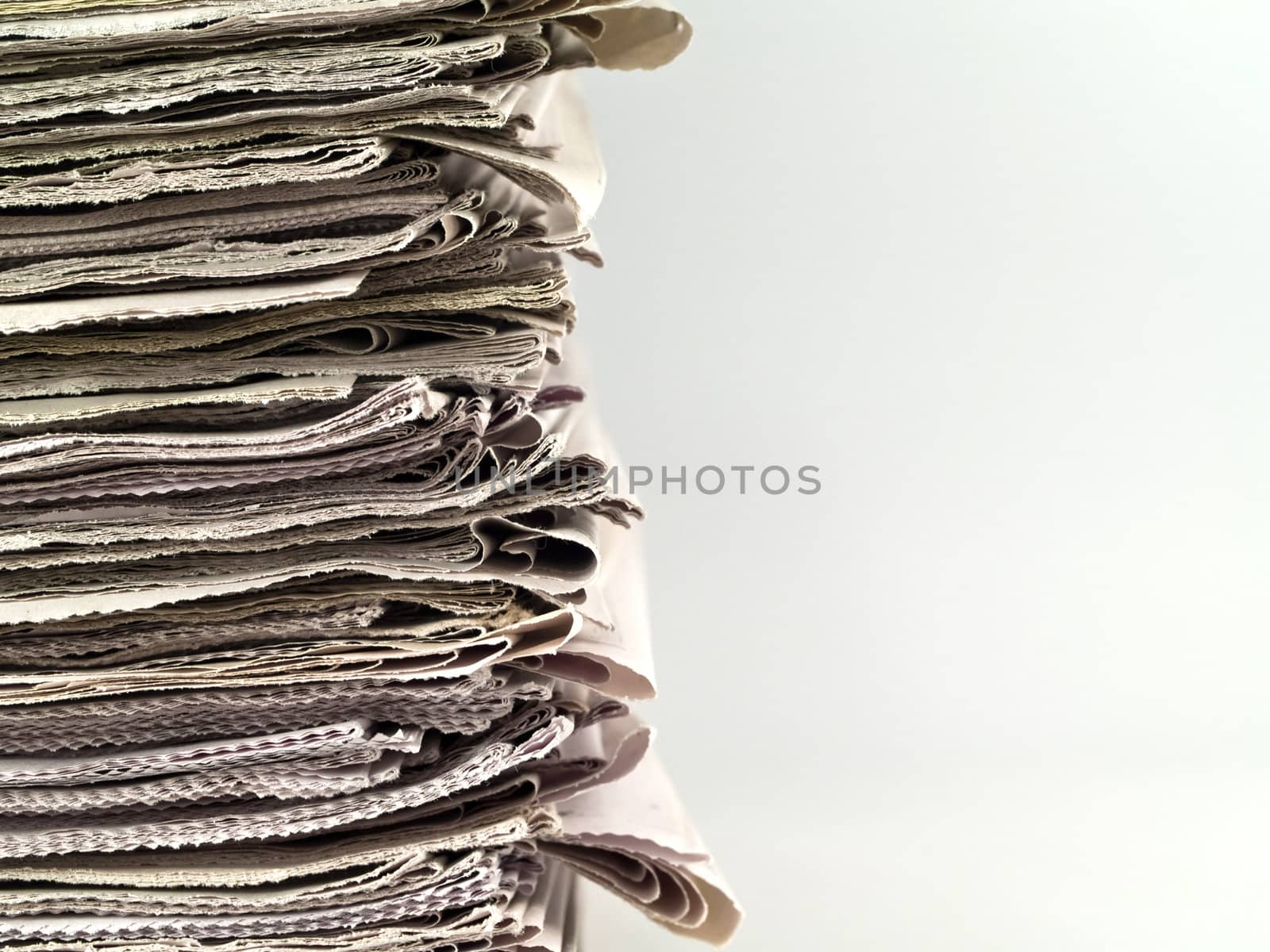 Old newspapers stacked from the top to bottom of the frame isolated on white