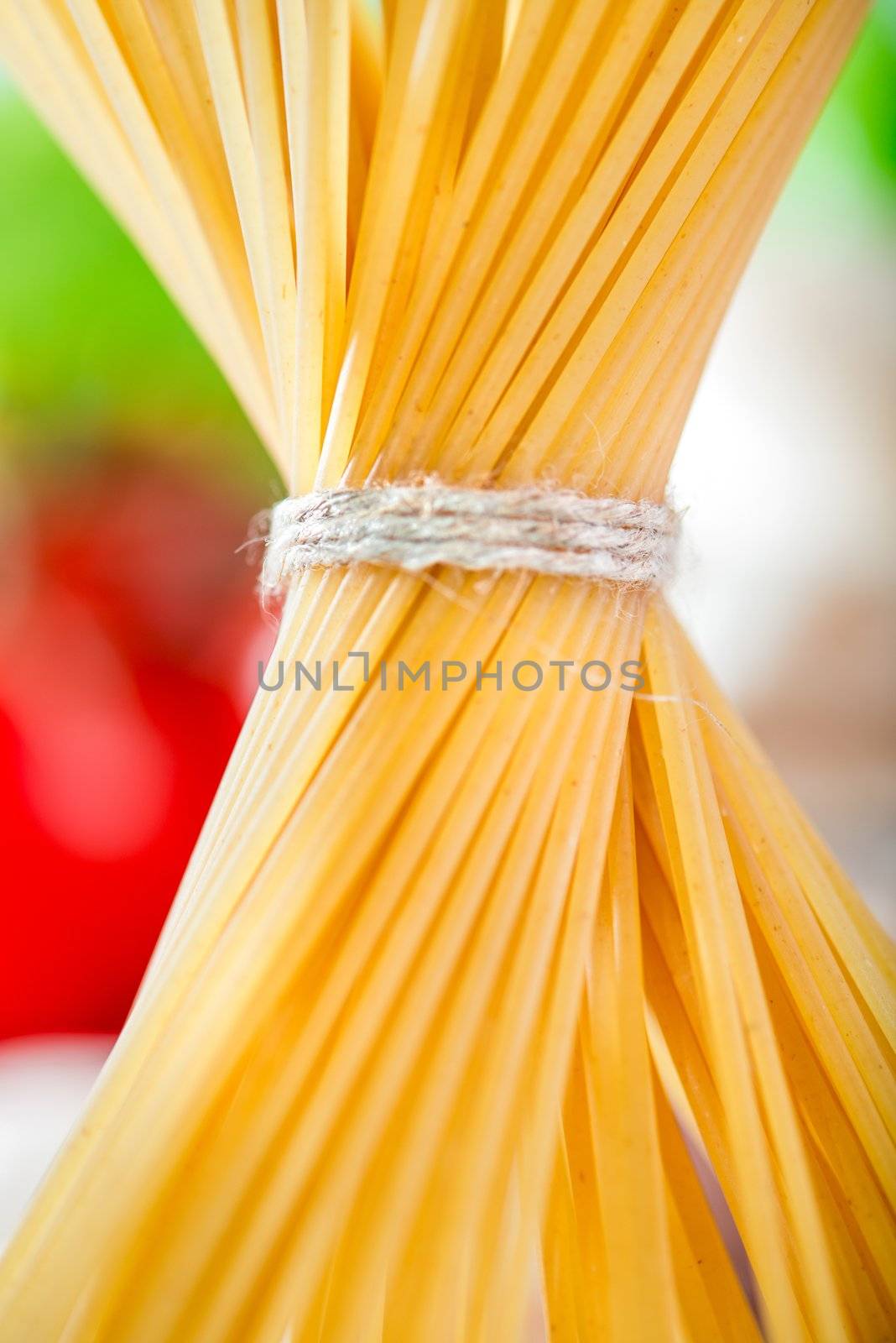 uncooked spaghetti tied with rope