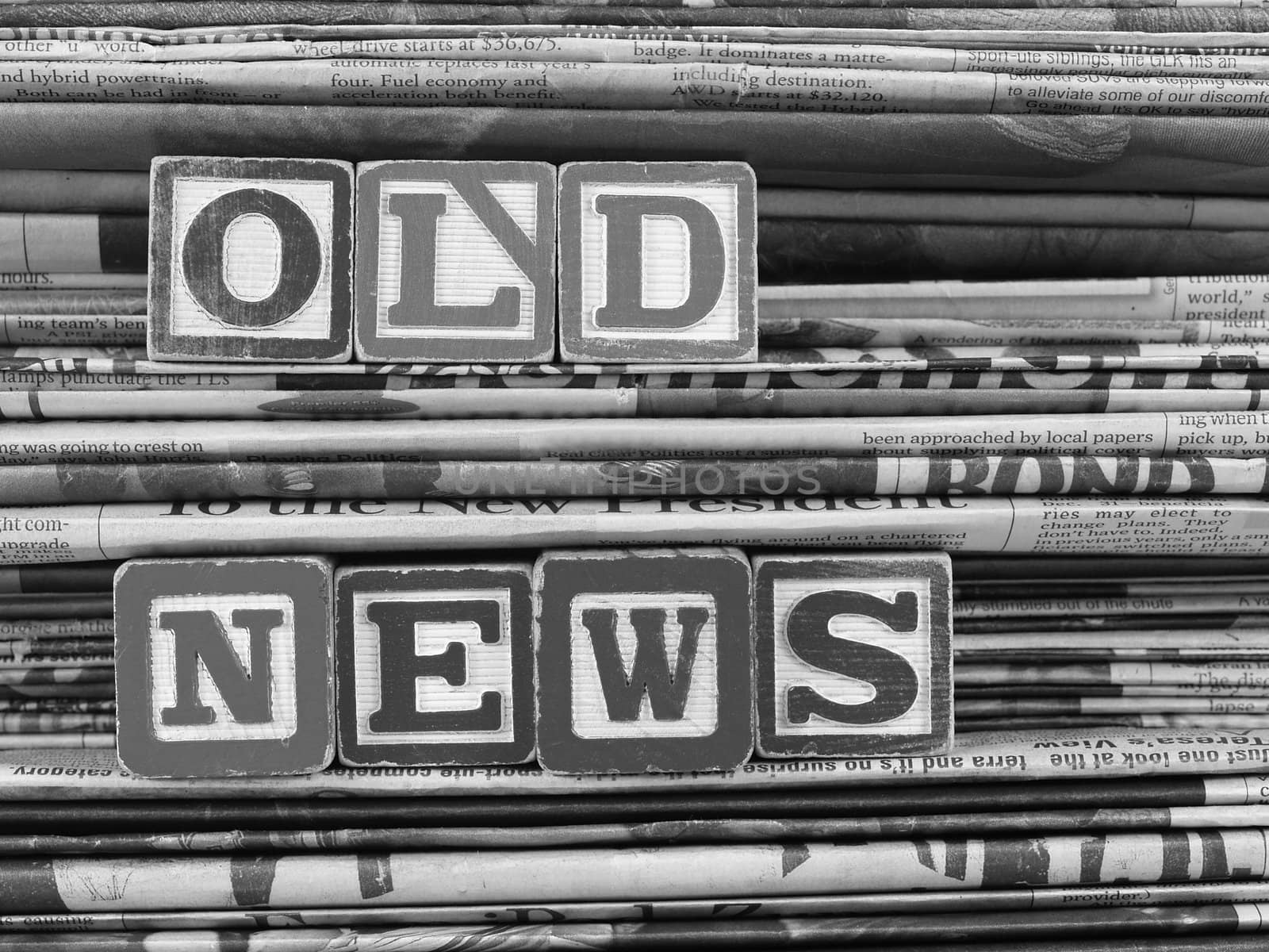 Old newspapers stacked and "Old News" is written in Block Letters. B&W 