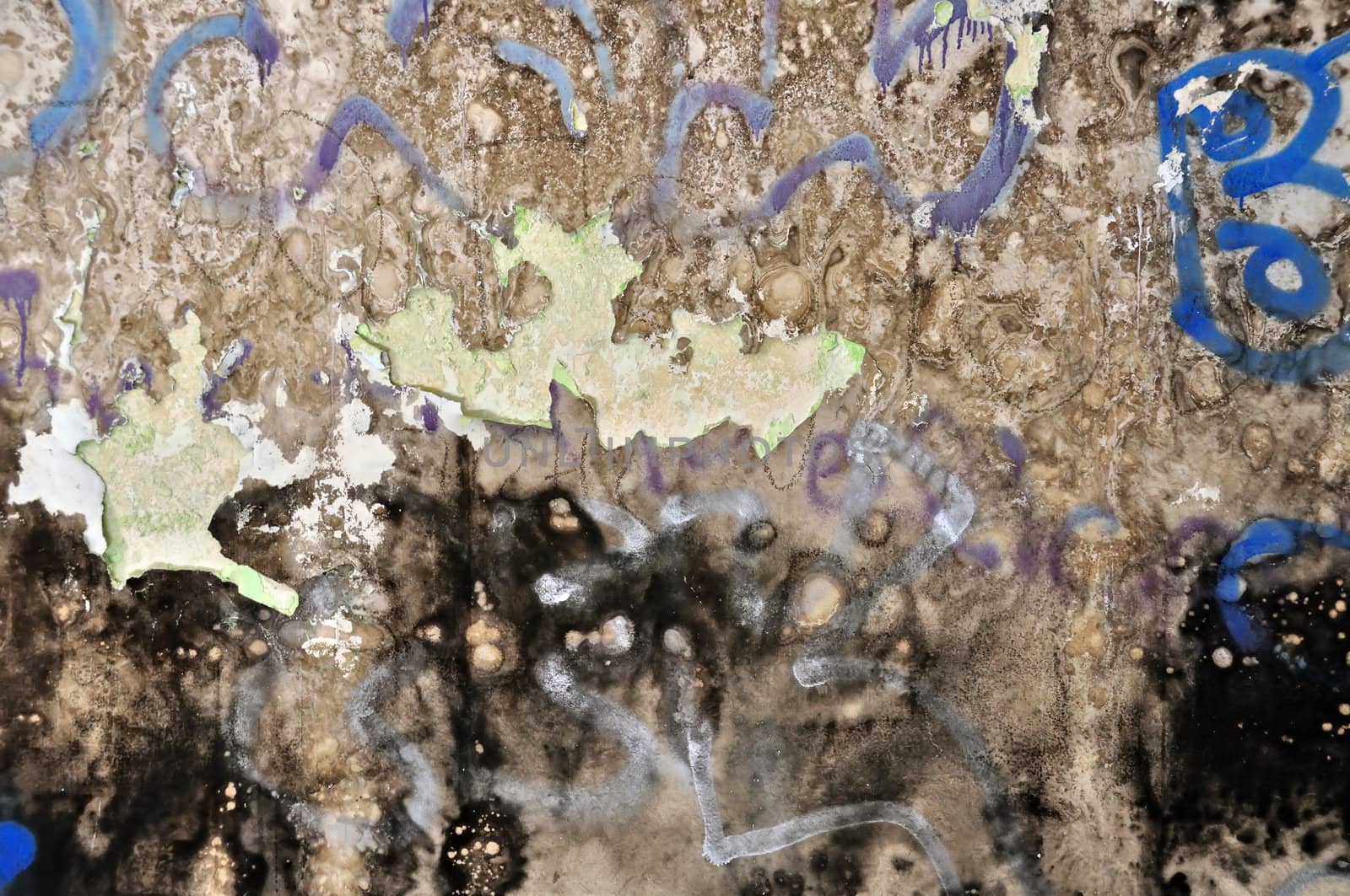 Old peeling grunge wall covered with messy graffiti and mold. Background texture.