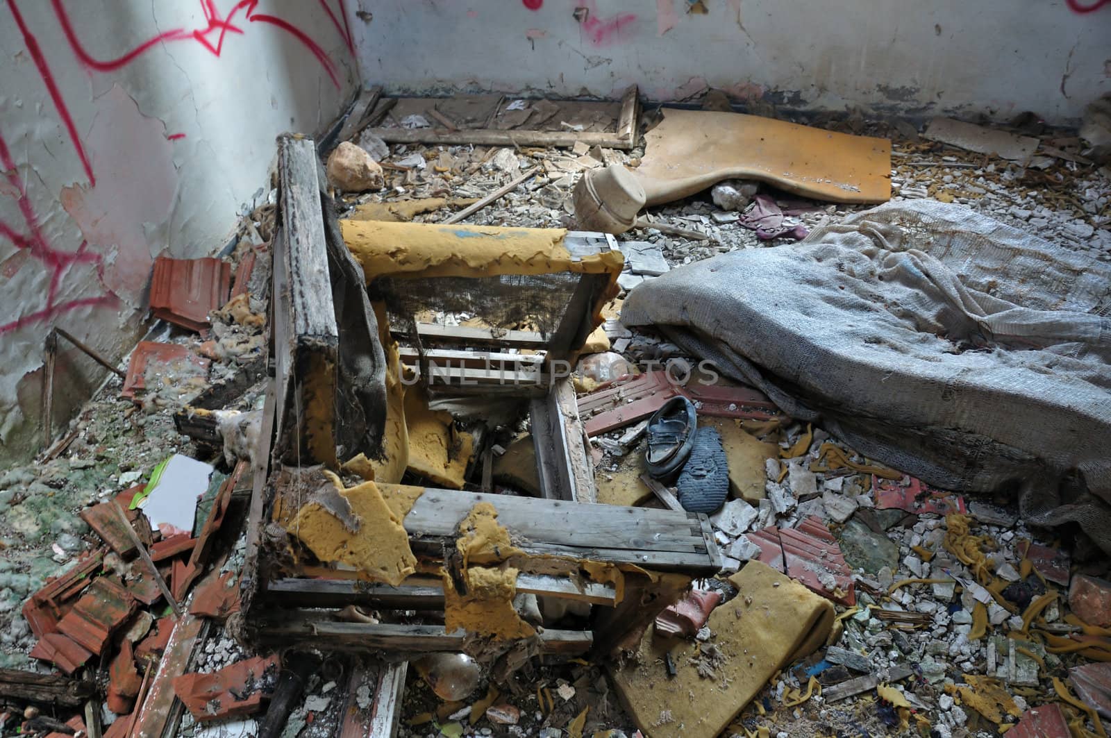 Weathered armchair in abandoned deteriorating house interior.