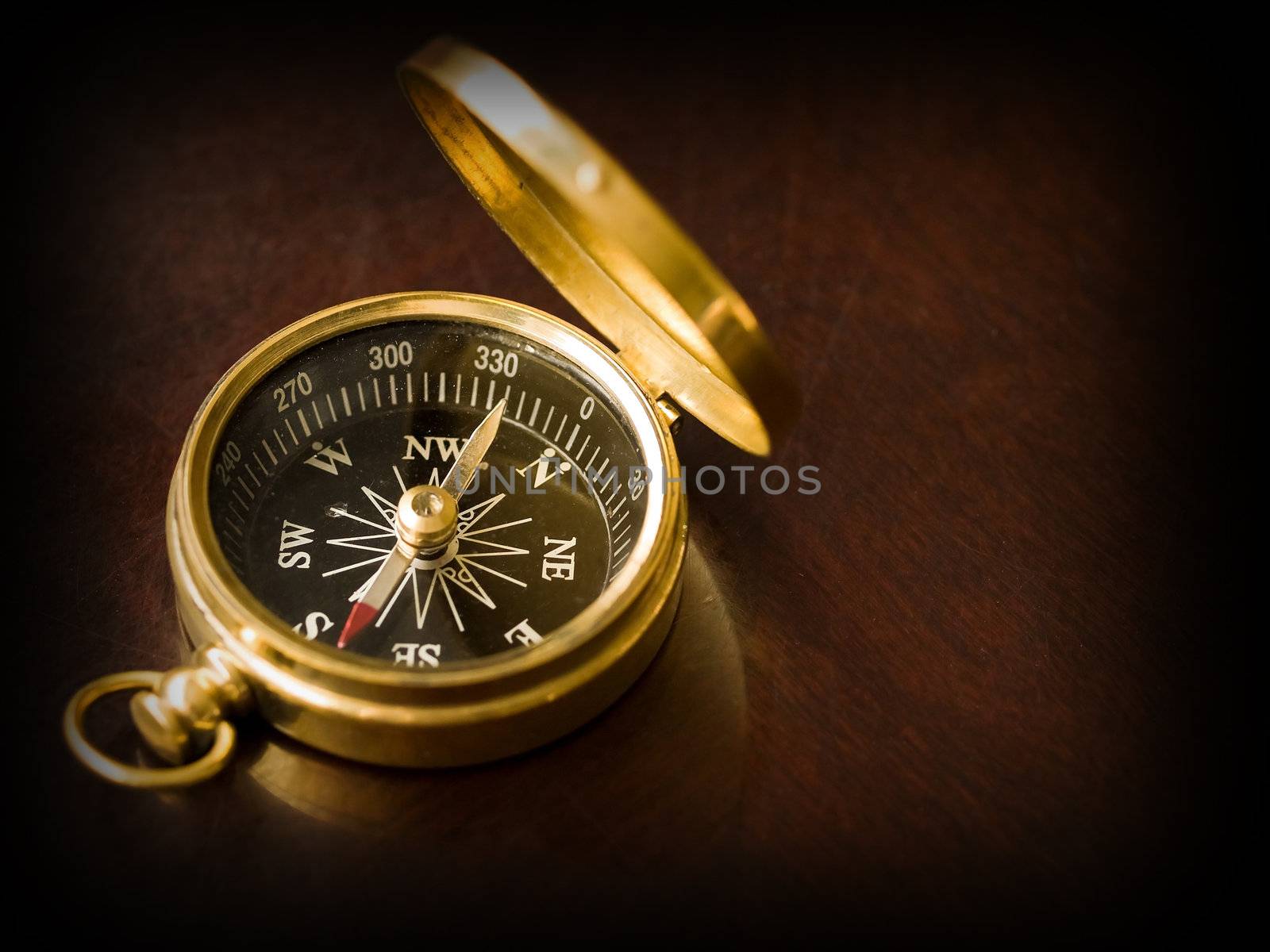 Brass Compass on an old cherrywood table with a dark border