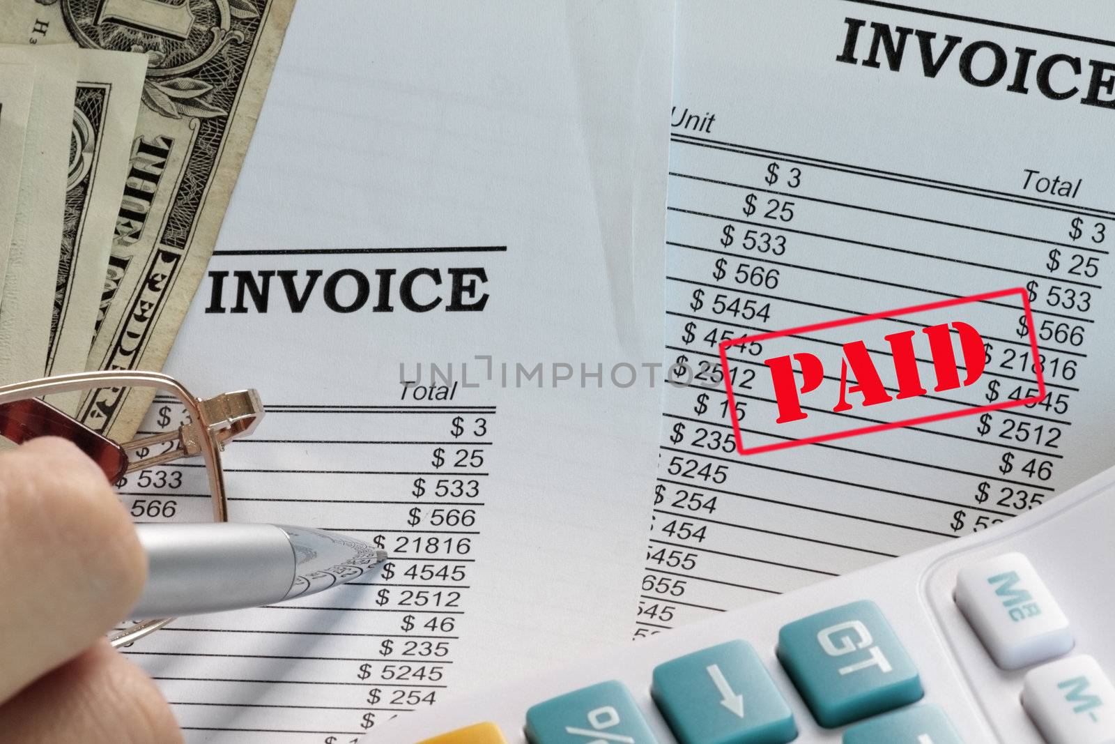Paid invoice in a spreadsheet with dollars and pen.