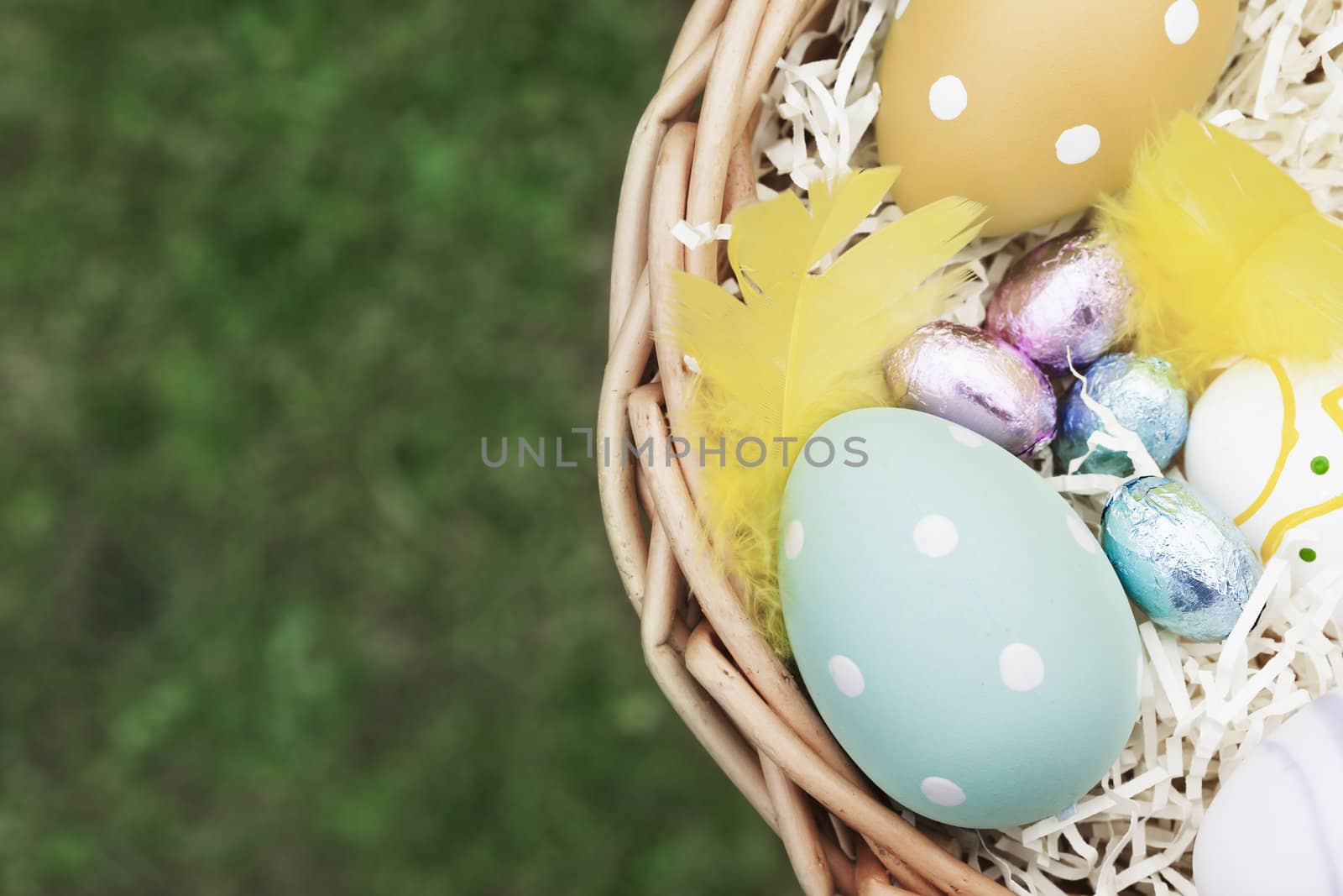 Decorated eggs and candy in Easter Basket, with copy space.