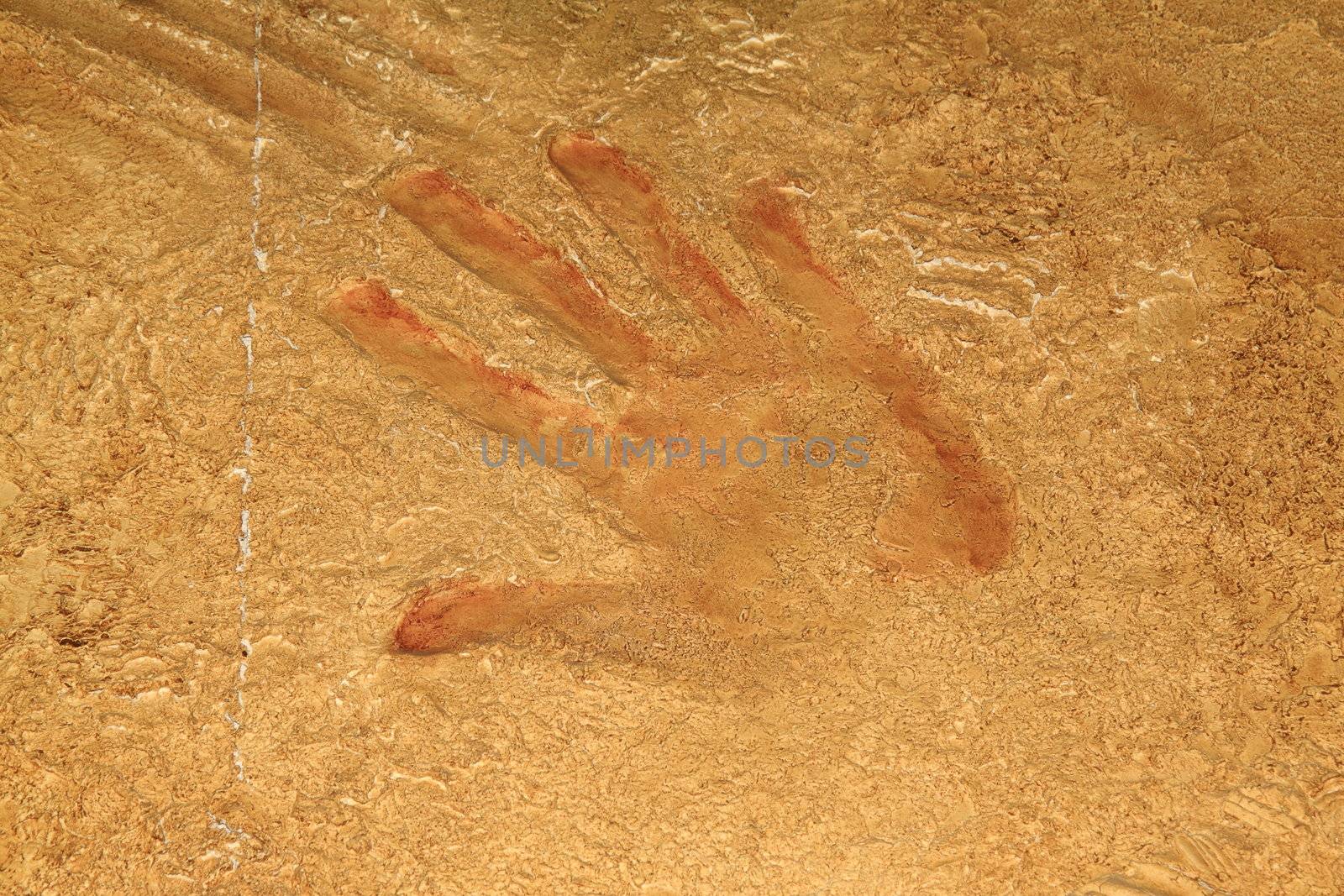 Red hand print on stone background or site
