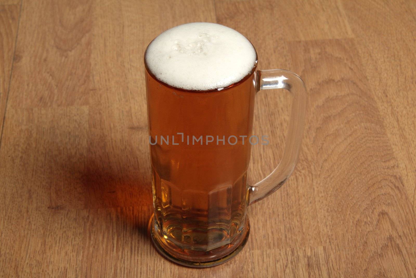 Single beer glass on wooden table background