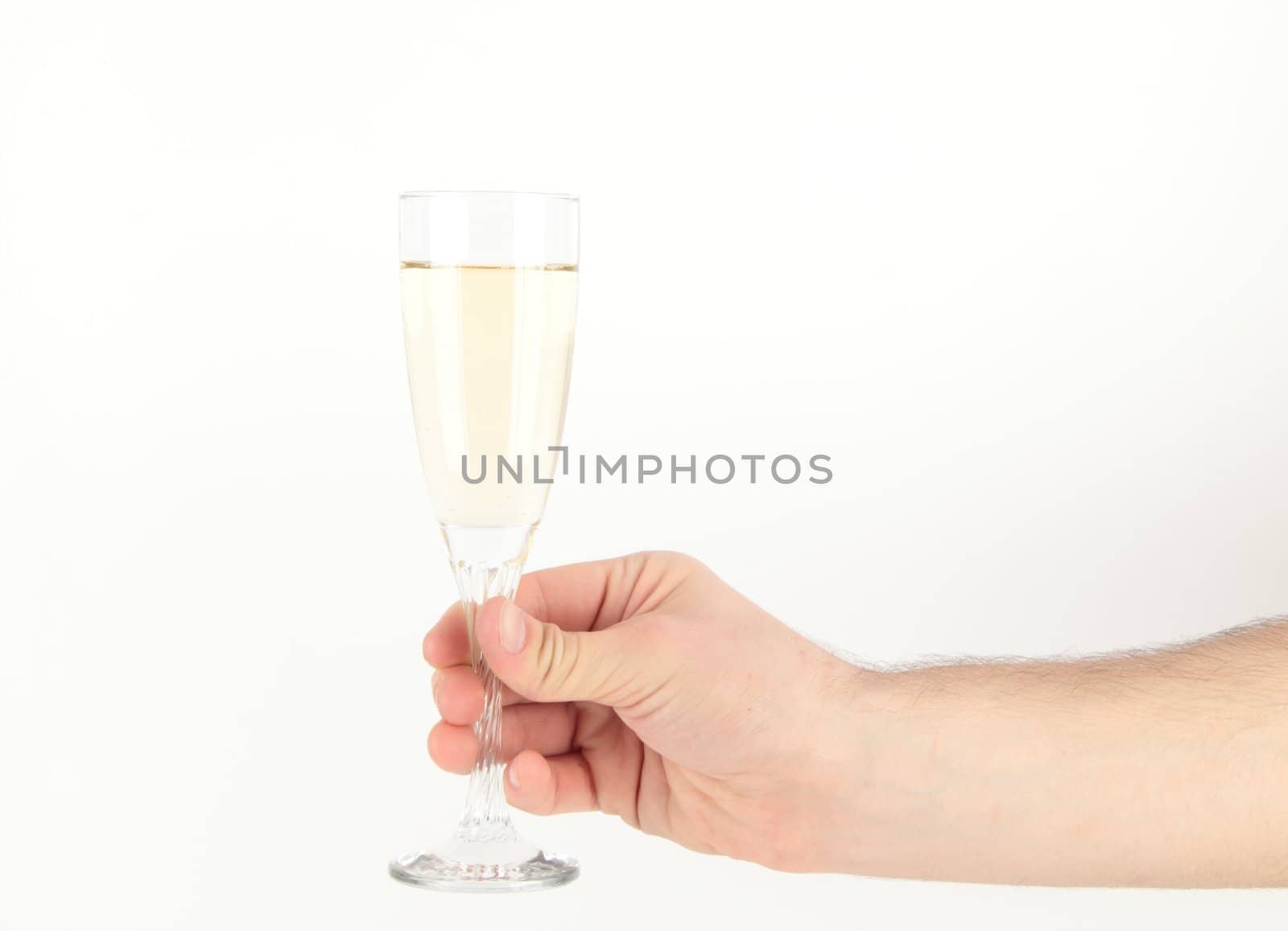 Hand holding glass of champagne on white background