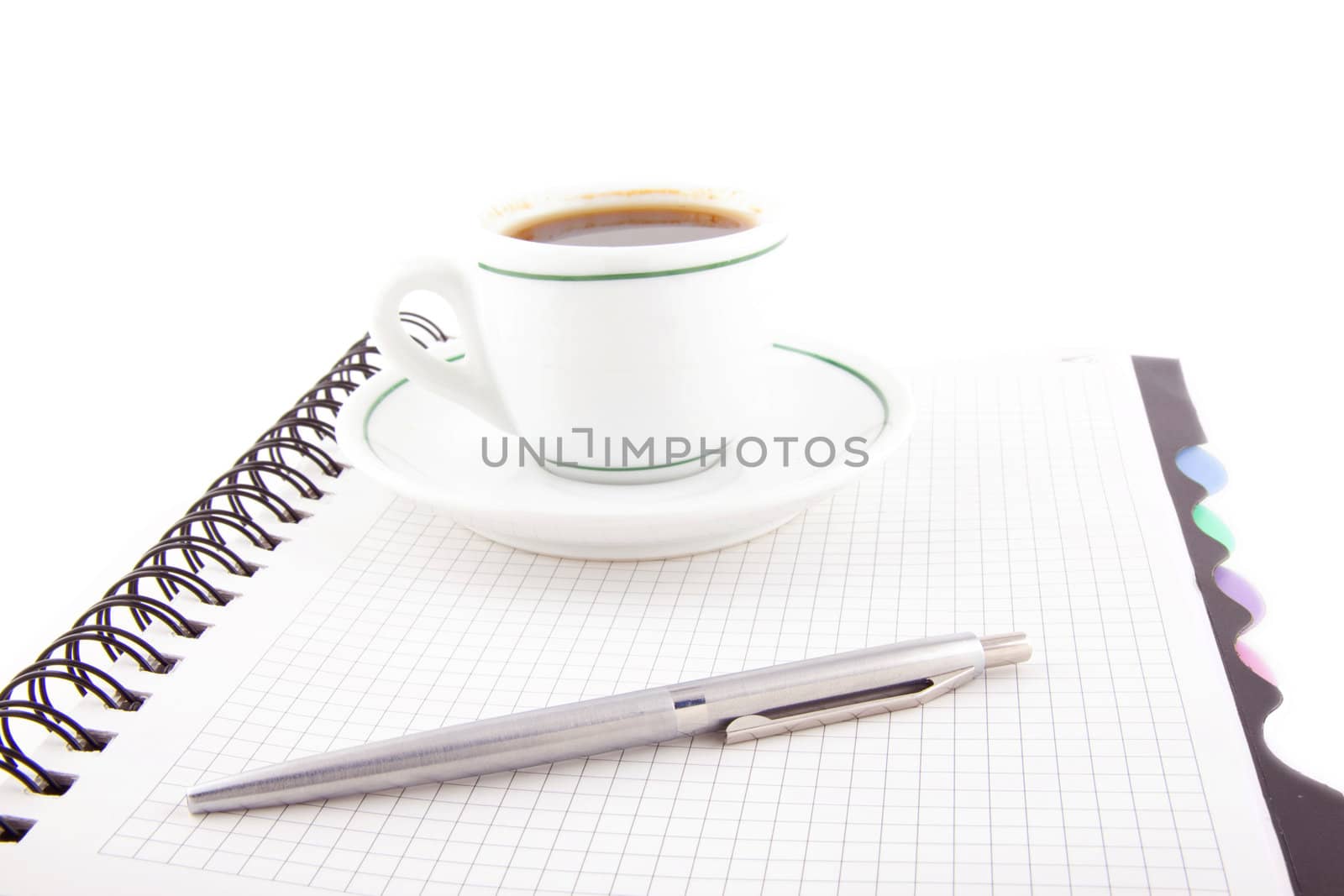 Coffee and pen on notebook isolated on white