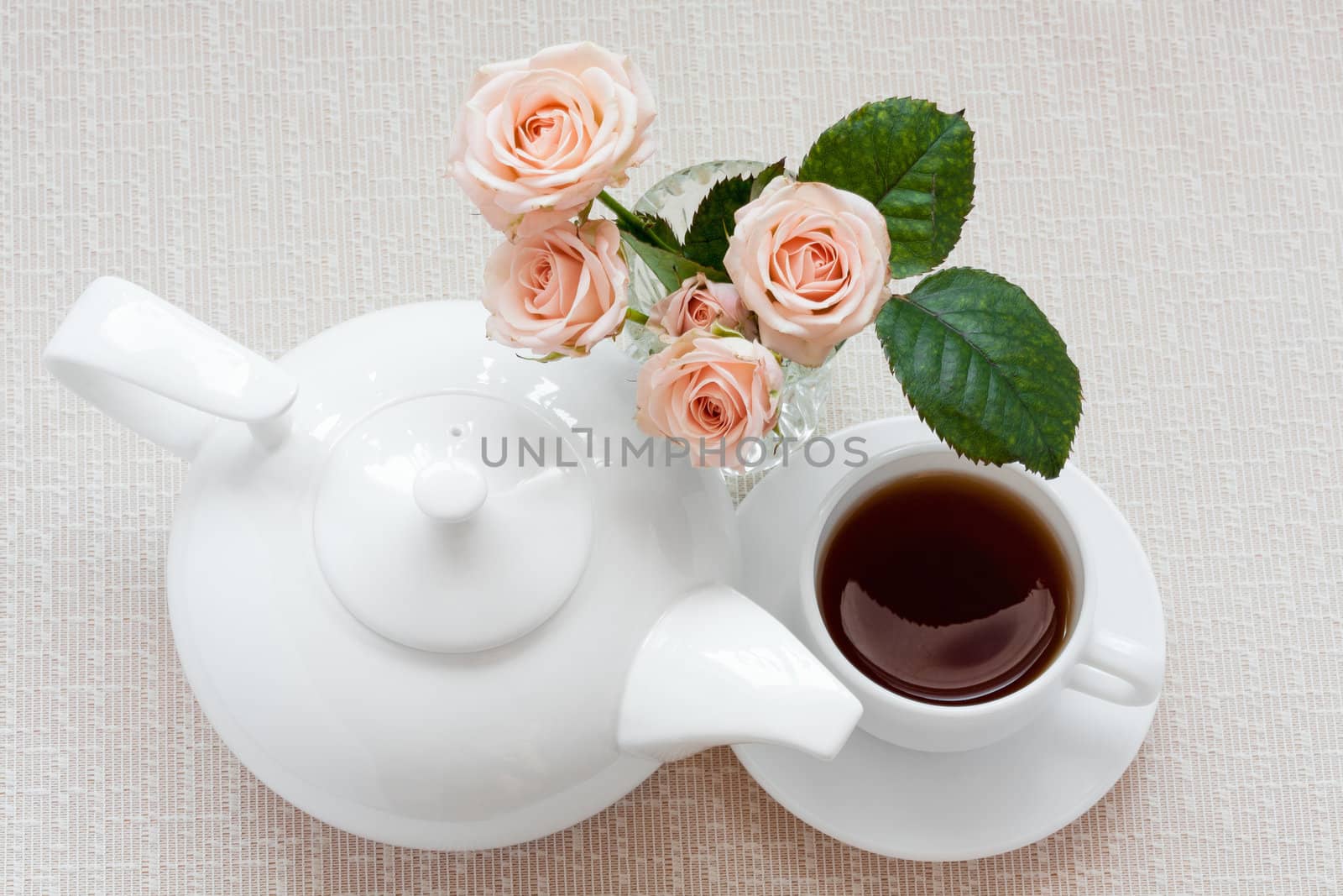 teapot, cup, and  roses on a plate