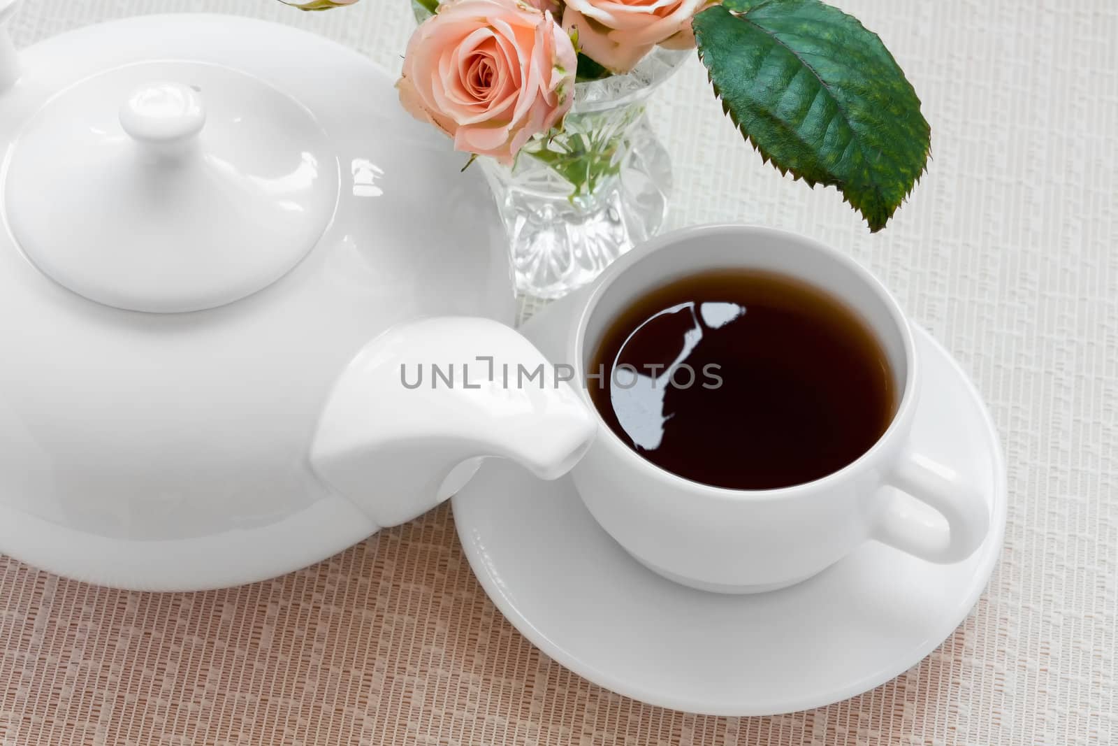 teapot, cup, and  roses on a plate